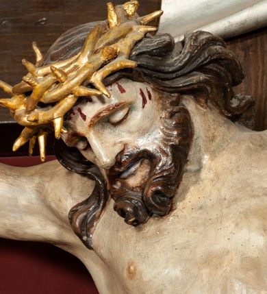 Zdjęcie nr 12: Ołtarz drewniany, dwustronny, obecnie przyścienny, architektoniczny, jednokondygnacyjny ze zwieńczeniem, trójosiowy, z bramkami. Mensa kamienna, prostopadłościenna z antepedium ujętym w profilowaną i złoconą ramę, dekorowaną kimationem jońskim i kampanulami. W polu płaskorzeźbione przedstawienie kielicha z hostią ujętego dwoma otwartymi księgami z napisem na prawej „ECCE / PANIS / ANGE/LORUM”, na lewej „EVAN/GE/LIUM”; liśćmi laurowymi, arma Christi; u podstawy kielicha nałożona korona cierniowa. W dolnych narożach antepedium dekoracja z miękko zawijającej się wstęgi regencyjnej. Tabernakulum o rozbudowanych architektonicznych formach, jednokondygnacyjne, trójosiowe, każda z osi flankowana parą kolumienek i zakończona zwieńczeniem. W osi środkowej tabernakulum metalowe: w dolnej części w formie prostopadłościennej skrzynki z wizerunkiem Chrystusa, w górnej części obrotowe z przedstawieniem Baranka Bożego, zamknięte ozdobnym zwieńczeniem z parą uskrzydlonych putt i koroną w typie zamkniętym. W polach osi bocznych umieszczone za szybką relikwie świętych ujęte prostokątną, złoconą ramą. Retabulum ustawione na wysokim, dwudzielnym cokole, z bramkami o otworach drzwiowych zamkniętych łukiem kotarowym ściętym, nadproża w formie profilowanego gryzmsu. Pole ołtarza, zarówno osi głównej jak i bocznych ujęte jest kolumnami o gładkich trzonach i złoconych kapitalach kompozytowych ustawionych na tle zwieloktrotnionych pilastrów o kanelowanych trzonach. Podpory dźwigają wyłamane na ich osi, pełne belkowanie z wydatnym, silnie profilowanych gzymsem. Na nim fragmenty przyczółka w formie wolut. Pole osi środkowej ze złoconą ramą zamkniętą łukiem wklęsło-wypukłym z uskokiem. W zwieńczeniu ramy wolutowy kartusz o nieregularnym kształcie, z napisem „CONSUMMATUM / EST”. W centrum pola ołtarzowego drewniany krycyfiks. W osi prawej figura św. Kazimierza Królewicza, w osi lewej figura św. Jadwigi Śląskiej. Rzeźby ustawione w niszach, zamkniętych łukiem wklęsło-wypukłym, na rozbudowanych, wolutowych konsolach dekorowanych z przodu kartuszem utworzonym z akantowego wieńca wypełnionego kratką regencyjną; ponad nim girlanda złożona z kampanul i kwiatów. W niszach ponad figurami umieszczone dużych rozmiarów, złocone muszle palmetowe, oraz nieco niżej dwie gałązki akantu. Ponad niszami rozbudowana płaskorzeźbiona dekoracja w formie struktury utworzonej z wolut o karbowanych wypełnieniach, w jej centrum uskrzydlone główki aniołków. Zwieńczenie w formie wklęsło-wypukłej, zamknięte gzymsem w kształcie łuku nadwieszonego, po bokach flankowane dwoma wazonami z kwiatami. W polu obraz św. Michała Archanioła. Kolorystyka ciemnozielona, ze złoceniami w partiach ornamentów oraz w załamaniach profili architektonicznych. Partie cokołu dekorowane płycinami wypełnionymi ornamentem regencyjnym. Według dokumentacji konserwatorskiej na odwrociu ołtarza znajduje się malowana iluzjonistyczna dekoracja przedstawiająca barokowy ołtarz, postacie Matki Boskiej, św. Jana Ewangelisty oraz świętych franciszkańskich.

