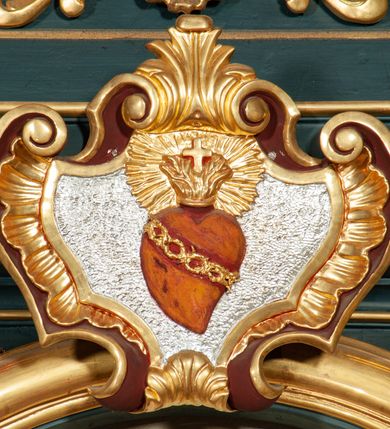 Zdjęcie nr 6: Ołtarz przyścienny, architektoniczny, jednokondygnacyjny, jednoosiowy, ze zwieńczeniem. Mensa w formie prostopadłościanu, antepedium malowane. Pośrodku medalion z wieńca laurowego. W polu wieńca krzyż oraz skrzyżowane narzędzia Męki Pańskiej na tle błękitnego nieba. Po bokach medalionu wolutowo zakręcona wić roślinna zakończona wazonami z kwiatami. Całość ukazana na ciemnozielonym tle. Retabulum umieszczone na zdwojonym cokole, flankowane kolumnami, ustawionymi na tle zwielokrotnionych pilastrów podtrzymujących wyłamane belkowanie; na osi kolumn przerwany wolutowy przyczółek. W polu głównym nastawy płytka wnęka, ujęta złoconą i profilowaną ramą w kształcie stojącego prostokąta zamkniętego łukiem wklęsło-wypukłym z uskokami. Pośrodku obraz „Najświętsze Serce Jezusa”. W górnej części ramy złocony kartusz z gorejącym sercem w polu. Zwieńczenie o delikatnie wklęsłych bokach ujętych spływami wolutowymi, zamknięte łukiem nadwieszonym. Nad nim złocona muszla palmetowa pomiędzy dwoma spływami wolutowymi. W polu zwieńczenia obraz „Św. Jan Kanty” w ramie o fantazyjnym wykroju. Retabulum flankowane po bokach ażurowymi uszami utworzonymi z liści akantu i przeplatającej je karbowanej wstęgi. Podpory ustawione na bazach, kapitele kompozytowe, trzony kolumn gładkie, natomiast trzony pilastrów kanelowane. Struktura malowana w kolorze ciemnozielonym, ornamenty i detale złocone.
