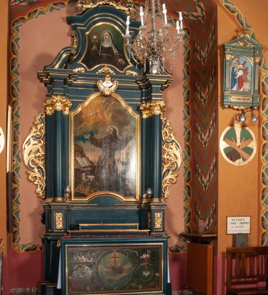Zdjęcie nr 2: Ołtarz przyścienny, architektoniczny, jednokondygnacyjny, jednoosiowy, ze zwieńczeniem.  Mensa w formie prostopadłościanu. Antepedium malowane. Pośrodku medalion z wieńca laurowego, owiniętego sznurem. W polu wieńca godło zakonu franciszkańskiego (skrzyżowane prawe ręce Chrystusa i św. Franciszka oraz krzyż łaciński) na tle błękitnego nieba. Po bokach medalionu wolutowo zakręcona wić roślinna zakończona wazonami z kwiatami. Całość ukazana na ciemnozielonym tle. Retabulum umieszczone na zdwojonym cokole, flankowane kolumnami, ustawionymi na tle zwielokrotnionych pilastrów podtrzymujących wyłamane belkowanie; na osi kolumn przerwany wolutowy przyczółek. W polu głównym nastawy płytka wnęka, ujęta złoconą i profilowaną ramą w kształcie stojącego prostokąta zamkniętego łukiem wklęsło-wypukłym z uskokami. Pośrodku obraz „Stygmatyzacja św. Franciszka”. W górnej części ramy złocony kartusz z godłem zakonu franciszkańskiego. Zwieńczenie o delikatnie wklęsłych bokach ujętych spływami wolutowymi, zamknięte łukiem nadwieszonym. Nad nim złocona muszla palmetowa pomiędzy dwoma spływami wolutowymi. W polu zwieńczenia obraz św. Klary w ramie o fantazyjnym wykroju. Retabulum flankowane po bokach ażurowymi uszami utworzonymi z liści akantu i przeplatającej je karbowanej wstęgi. Podpory ustawione na bazach, kapitele kompozytowe, trzony kolumn gładkie, natomiast trzony pilastrów kanelowane. Struktura malowana w kolorze ciemnozielonym, ornamenty i detale złocone.
