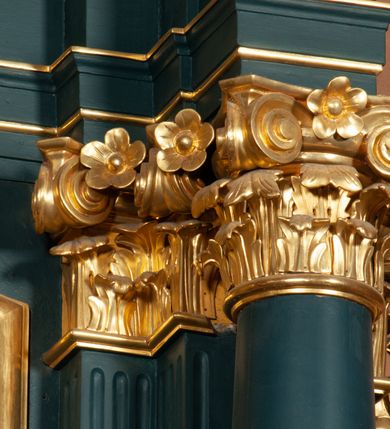 Zdjęcie nr 13: Ołtarz przyścienny, architektoniczny, jednokondygnacyjny, jednoosiowy, ze zwieńczeniem.  Mensa w formie prostopadłościanu. Antepedium malowane. Pośrodku medalion z wieńca laurowego, owiniętego sznurem. W polu wieńca godło zakonu franciszkańskiego (skrzyżowane prawe ręce Chrystusa i św. Franciszka oraz krzyż łaciński) na tle błękitnego nieba. Po bokach medalionu wolutowo zakręcona wić roślinna zakończona wazonami z kwiatami. Całość ukazana na ciemnozielonym tle. Retabulum umieszczone na zdwojonym cokole, flankowane kolumnami, ustawionymi na tle zwielokrotnionych pilastrów podtrzymujących wyłamane belkowanie; na osi kolumn przerwany wolutowy przyczółek. W polu głównym nastawy płytka wnęka, ujęta złoconą i profilowaną ramą w kształcie stojącego prostokąta zamkniętego łukiem wklęsło-wypukłym z uskokami. Pośrodku obraz „Stygmatyzacja św. Franciszka”. W górnej części ramy złocony kartusz z godłem zakonu franciszkańskiego. Zwieńczenie o delikatnie wklęsłych bokach ujętych spływami wolutowymi, zamknięte łukiem nadwieszonym. Nad nim złocona muszla palmetowa pomiędzy dwoma spływami wolutowymi. W polu zwieńczenia obraz św. Klary w ramie o fantazyjnym wykroju. Retabulum flankowane po bokach ażurowymi uszami utworzonymi z liści akantu i przeplatającej je karbowanej wstęgi. Podpory ustawione na bazach, kapitele kompozytowe, trzony kolumn gładkie, natomiast trzony pilastrów kanelowane. Struktura malowana w kolorze ciemnozielonym, ornamenty i detale złocone.
