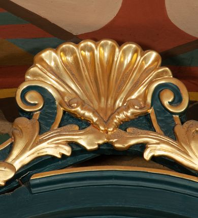 Zdjęcie nr 18: Ołtarz przyścienny, architektoniczny, jednokondygnacyjny, jednoosiowy, ze zwieńczeniem.  Mensa w formie prostopadłościanu. Antepedium malowane. Pośrodku medalion z wieńca laurowego, owiniętego sznurem. W polu wieńca godło zakonu franciszkańskiego (skrzyżowane prawe ręce Chrystusa i św. Franciszka oraz krzyż łaciński) na tle błękitnego nieba. Po bokach medalionu wolutowo zakręcona wić roślinna zakończona wazonami z kwiatami. Całość ukazana na ciemnozielonym tle. Retabulum umieszczone na zdwojonym cokole, flankowane kolumnami, ustawionymi na tle zwielokrotnionych pilastrów podtrzymujących wyłamane belkowanie; na osi kolumn przerwany wolutowy przyczółek. W polu głównym nastawy płytka wnęka, ujęta złoconą i profilowaną ramą w kształcie stojącego prostokąta zamkniętego łukiem wklęsło-wypukłym z uskokami. Pośrodku obraz „Stygmatyzacja św. Franciszka”. W górnej części ramy złocony kartusz z godłem zakonu franciszkańskiego. Zwieńczenie o delikatnie wklęsłych bokach ujętych spływami wolutowymi, zamknięte łukiem nadwieszonym. Nad nim złocona muszla palmetowa pomiędzy dwoma spływami wolutowymi. W polu zwieńczenia obraz św. Klary w ramie o fantazyjnym wykroju. Retabulum flankowane po bokach ażurowymi uszami utworzonymi z liści akantu i przeplatającej je karbowanej wstęgi. Podpory ustawione na bazach, kapitele kompozytowe, trzony kolumn gładkie, natomiast trzony pilastrów kanelowane. Struktura malowana w kolorze ciemnozielonym, ornamenty i detale złocone.
