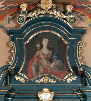 Zdjęcie nr 6: Ołtarz przyścienny, architektoniczny, jednokondygnacyjny, jednoosiowy, ze zwieńczeniem. Mensa w formie prostopadłościanu. Antepedium drewniane, w centrum złocony ormament roślinny oraz banderola.  Retabulum ustawione na zdwojonym cokole, flankowane kolumnami, ustawionych na tle zwielokrotnionych pilastrów podtrzymujących wyłamane belkowanie, na osi kolumn przerwany wolutowy przyczółek. W polu głównym nastawy płytka wnęka, ujęta złoconą i profilowaną ramą w kształcie stojącego prostokąta zamkniętego łukiem wklęsło-wypukłym z uskokami. Pośrodku obraz Matki Boskiej Częstochowskiej. W górnej części ramy złocony kartusz. Zwieńczenie o delikatnie wklęsłych bokach ze spływami wolutowymi, zamknięte łukiem nadwieszonym. Nad nim złocona muszla palmetowa ujęta dwoma spływami wolutowymi. W polu zwieńczenia obraz św. Barbary w ramie o fantazyjnym wykroju. Retabulum flankowane po bokach ażurowymi uszami utworzonymi z liści akantu. Podpory ustawione na bazach, kapitele kompozytowe, trzony kolumn gładkie, natomiast trzony pilastrów kanelowane. Struktura malowana w kolorze ciemnozielonym, ornamenty i detale złocone.