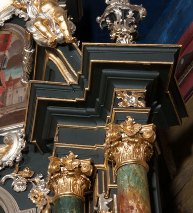 Zdjęcie nr 11: Nastawa architektoniczna, jednoosiowa z bramkami, jednokondygnacyjna ze zwieńczeniem, na dwustrefowym cokole. Ołtarz drewniany prostopadłościenny z kamienną mensą. Antepedium ujęte profilowaną ramą, wykonane z czerwonego, haftowanego aksamitu, w centrum medalion z przedstawieniem baranka leżącego na księdze, w dolnych narożach motywy kwiatowe. 
Retabulum flankowane ustawionymi pod kątem na zewnątrz dwiema parami korynckich kolumn, umieszczonych na tle kanelowanych pilastrów. Kolumny ustawione na cokołach, podtrzymują wyłamane belkowanie, przerwane nad polem środkowym, oraz przerwany falisty przyczółek. Na belkowaniu stoi para wazonów, na przerwanym przyczółku siedzą dwa putta. Pomiędzy kolumnami na cokołach znajdują się figury św. Jana Kantego i św. Jana Nepomucena. W polu głównym obraz z przedstawieniem św. Sebastiana ujęty profilowaną ramą w formie stojącego prostokąta zamkniętego łukiem półkolistym nadwieszonym z uskokiem, zwieńczoną rokokowym kartuszem flankowanym kwiatowymi zwisami. Zwieńczenie w formie stojącego prostokąta ujęte pilastrami o trzonach przechodzących w spływy wolutowe, zamknięte rokokowym kartuszem. W polu przedstawienie św. Floriana w profilowanej ramie w formie stojącego prostokąta zamkniętego łukiem półkolistym nadwieszonym. Bramki na wysokości cokołu nastawy w formie arkad podtrzymywanych przez pilastry, zwieńczonych racaille&#039;owymi szczytami. Dwustrefowy cokół dekorowany rokokowymi płycinami, rocaille&#039;m, rozetami i kartuszami. Kanelowane pilastry nastawy ozdobione kampanulami oraz bogatymi, kwiatowymi zwisami. Nastawa ujęta małymi uszami utworzonymi z liści palmy. 
Struktura architektoniczna polichromowana w kolorze czarnym, trzony kolumn pokryte polichromią imitującą kolorową marmoryzację, dekoracja rzeźbiarska, ornamentalna oraz profile pozłacane i posrebrzane. 

