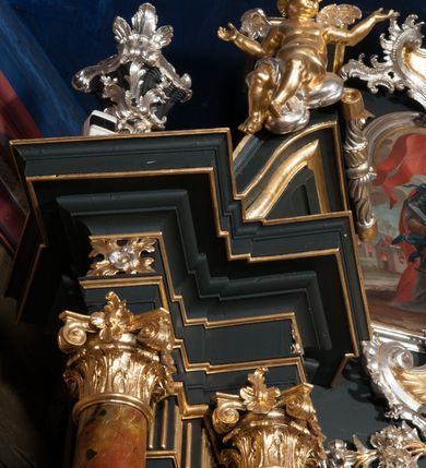 Zdjęcie nr 9: Nastawa architektoniczna, jednoosiowa z bramkami, jednokondygnacyjna ze zwieńczeniem, na dwustrefowym cokole. Ołtarz drewniany prostopadłościenny z kamienną mensą. Antepedium ujęte profilowaną ramą, wykonane z czerwonego, haftowanego aksamitu, w centrum medalion z przedstawieniem baranka leżącego na księdze, w dolnych narożach motywy kwiatowe. 
Retabulum flankowane ustawionymi pod kątem na zewnątrz dwiema parami korynckich kolumn, umieszczonych na tle kanelowanych pilastrów. Kolumny ustawione na cokołach, podtrzymują wyłamane belkowanie, przerwane nad polem środkowym, oraz przerwany falisty przyczółek. Na belkowaniu stoi para wazonów, na przerwanym przyczółku siedzą dwa putta. Pomiędzy kolumnami na cokołach znajdują się figury św. Jana Kantego i św. Jana Nepomucena. W polu głównym obraz z przedstawieniem św. Sebastiana ujęty profilowaną ramą w formie stojącego prostokąta zamkniętego łukiem półkolistym nadwieszonym z uskokiem, zwieńczoną rokokowym kartuszem flankowanym kwiatowymi zwisami. Zwieńczenie w formie stojącego prostokąta ujęte pilastrami o trzonach przechodzących w spływy wolutowe, zamknięte rokokowym kartuszem. W polu przedstawienie św. Floriana w profilowanej ramie w formie stojącego prostokąta zamkniętego łukiem półkolistym nadwieszonym. Bramki na wysokości cokołu nastawy w formie arkad podtrzymywanych przez pilastry, zwieńczonych racaille&#039;owymi szczytami. Dwustrefowy cokół dekorowany rokokowymi płycinami, rocaille&#039;m, rozetami i kartuszami. Kanelowane pilastry nastawy ozdobione kampanulami oraz bogatymi, kwiatowymi zwisami. Nastawa ujęta małymi uszami utworzonymi z liści palmy. 
Struktura architektoniczna polichromowana w kolorze czarnym, trzony kolumn pokryte polichromią imitującą kolorową marmoryzację, dekoracja rzeźbiarska, ornamentalna oraz profile pozłacane i posrebrzane. 

