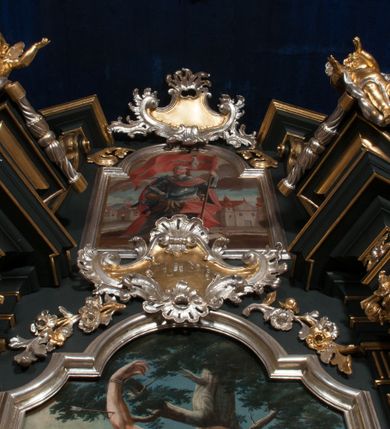 Zdjęcie nr 10: Nastawa architektoniczna, jednoosiowa z bramkami, jednokondygnacyjna ze zwieńczeniem, na dwustrefowym cokole. Ołtarz drewniany prostopadłościenny z kamienną mensą. Antepedium ujęte profilowaną ramą, wykonane z czerwonego, haftowanego aksamitu, w centrum medalion z przedstawieniem baranka leżącego na księdze, w dolnych narożach motywy kwiatowe. 
Retabulum flankowane ustawionymi pod kątem na zewnątrz dwiema parami korynckich kolumn, umieszczonych na tle kanelowanych pilastrów. Kolumny ustawione na cokołach, podtrzymują wyłamane belkowanie, przerwane nad polem środkowym, oraz przerwany falisty przyczółek. Na belkowaniu stoi para wazonów, na przerwanym przyczółku siedzą dwa putta. Pomiędzy kolumnami na cokołach znajdują się figury św. Jana Kantego i św. Jana Nepomucena. W polu głównym obraz z przedstawieniem św. Sebastiana ujęty profilowaną ramą w formie stojącego prostokąta zamkniętego łukiem półkolistym nadwieszonym z uskokiem, zwieńczoną rokokowym kartuszem flankowanym kwiatowymi zwisami. Zwieńczenie w formie stojącego prostokąta ujęte pilastrami o trzonach przechodzących w spływy wolutowe, zamknięte rokokowym kartuszem. W polu przedstawienie św. Floriana w profilowanej ramie w formie stojącego prostokąta zamkniętego łukiem półkolistym nadwieszonym. Bramki na wysokości cokołu nastawy w formie arkad podtrzymywanych przez pilastry, zwieńczonych racaille&#039;owymi szczytami. Dwustrefowy cokół dekorowany rokokowymi płycinami, rocaille&#039;m, rozetami i kartuszami. Kanelowane pilastry nastawy ozdobione kampanulami oraz bogatymi, kwiatowymi zwisami. Nastawa ujęta małymi uszami utworzonymi z liści palmy. 
Struktura architektoniczna polichromowana w kolorze czarnym, trzony kolumn pokryte polichromią imitującą kolorową marmoryzację, dekoracja rzeźbiarska, ornamentalna oraz profile pozłacane i posrebrzane. 

