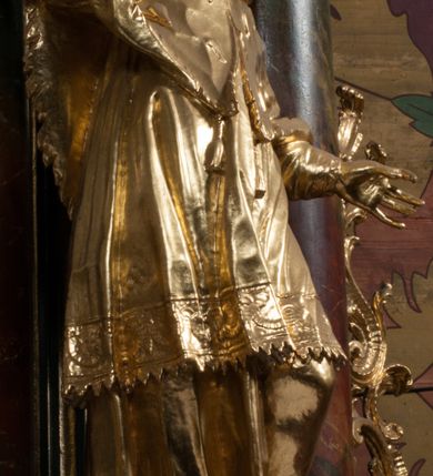 Zdjęcie nr 24: Nastawa architektoniczna, jednoosiowa z bramkami, jednokondygnacyjna ze zwieńczeniem, na dwustrefowym cokole. Ołtarz drewniany prostopadłościenny z kamienną mensą. Antepedium ujęte profilowaną ramą, wykonane z czerwonego, haftowanego aksamitu, w centrum medalion z przedstawieniem baranka leżącego na księdze, w dolnych narożach motywy kwiatowe. 
Retabulum flankowane ustawionymi pod kątem na zewnątrz dwiema parami korynckich kolumn, umieszczonych na tle kanelowanych pilastrów. Kolumny ustawione na cokołach, podtrzymują wyłamane belkowanie, przerwane nad polem środkowym, oraz przerwany falisty przyczółek. Na belkowaniu stoi para wazonów, na przerwanym przyczółku siedzą dwa putta. Pomiędzy kolumnami na cokołach znajdują się figury św. Jana Kantego i św. Jana Nepomucena. W polu głównym obraz z przedstawieniem św. Sebastiana ujęty profilowaną ramą w formie stojącego prostokąta zamkniętego łukiem półkolistym nadwieszonym z uskokiem, zwieńczoną rokokowym kartuszem flankowanym kwiatowymi zwisami. Zwieńczenie w formie stojącego prostokąta ujęte pilastrami o trzonach przechodzących w spływy wolutowe, zamknięte rokokowym kartuszem. W polu przedstawienie św. Floriana w profilowanej ramie w formie stojącego prostokąta zamkniętego łukiem półkolistym nadwieszonym. Bramki na wysokości cokołu nastawy w formie arkad podtrzymywanych przez pilastry, zwieńczonych racaille'owymi szczytami. Dwustrefowy cokół dekorowany rokokowymi płycinami, rocaille'm, rozetami i kartuszami. Kanelowane pilastry nastawy ozdobione kampanulami oraz bogatymi, kwiatowymi zwisami. Nastawa ujęta małymi uszami utworzonymi z liści palmy. 
Struktura architektoniczna polichromowana w kolorze czarnym, trzony kolumn pokryte polichromią imitującą kolorową marmoryzację, dekoracja rzeźbiarska, ornamentalna oraz profile pozłacane i posrebrzane. 

