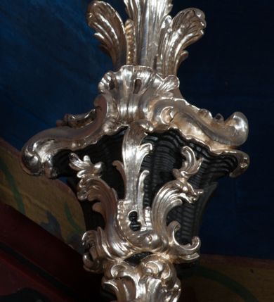 Zdjęcie nr 5: Nastawa architektoniczna, jednoosiowa z bramkami, jednokondygnacyjna ze zwieńczeniem, na dwustrefowym cokole. Ołtarz drewniany prostopadłościenny z kamienną mensą. Antepedium ujęte profilowaną ramą, wykonane z czerwonego, haftowanego aksamitu, w centrum medalion z przedstawieniem baranka leżącego na księdze, w dolnych narożach motywy kwiatowe. 
Retabulum flankowane ustawionymi pod kątem na zewnątrz dwiema parami korynckich kolumn, umieszczonych na tle kanelowanych pilastrów. Kolumny ustawione na cokołach, podtrzymują wyłamane belkowanie, przerwane nad polem środkowym, oraz przerwany falisty przyczółek. Na belkowaniu stoi para wazonów, na przerwanym przyczółku siedzą dwa putta. Pomiędzy kolumnami na cokołach znajdują się figury św. Jana Kantego i św. Jana Nepomucena. W polu głównym obraz z przedstawieniem św. Sebastiana ujęty profilowaną ramą w formie stojącego prostokąta zamkniętego łukiem półkolistym nadwieszonym z uskokiem, zwieńczoną rokokowym kartuszem flankowanym kwiatowymi zwisami. Zwieńczenie w formie stojącego prostokąta ujęte pilastrami o trzonach przechodzących w spływy wolutowe, zamknięte rokokowym kartuszem. W polu przedstawienie św. Floriana w profilowanej ramie w formie stojącego prostokąta zamkniętego łukiem półkolistym nadwieszonym. Bramki na wysokości cokołu nastawy w formie arkad podtrzymywanych przez pilastry, zwieńczonych racaille'owymi szczytami. Dwustrefowy cokół dekorowany rokokowymi płycinami, rocaille'm, rozetami i kartuszami. Kanelowane pilastry nastawy ozdobione kampanulami oraz bogatymi, kwiatowymi zwisami. Nastawa ujęta małymi uszami utworzonymi z liści palmy. 
Struktura architektoniczna polichromowana w kolorze czarnym, trzony kolumn pokryte polichromią imitującą kolorową marmoryzację, dekoracja rzeźbiarska, ornamentalna oraz profile pozłacane i posrebrzane. 

