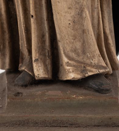 Zdjęcie nr 14: Figura jest pełnoplastyczna, ustawiona na profilowanym cokole na planie prostokąta. Święty przedstawiony w całej postaci, zwrócony jest frontalnie, w kontrapoście, z głową skierowaną w prawo. Obie ręce wyciąga przed siebie, w prawej trzyma pastorał. Twarz ma pociągłą, o  oczach skierowanych w dół, dużym, garbatym nosie i niewielkich ustach, okoloną długą brodą uformowaną w pojedyncze pukle, opadającą na pierś oraz krótkimi, silnie kręconymi włosami. Święty ubrany jest w strój biskupa: białą albę przepasaną w talii, czerwoną stułę, czerwoną kapę z niebieską podszewką, zapiętą na piersi, na głowie ma czerwoną infułę. Polichromia ciała naturalistyczna. 
