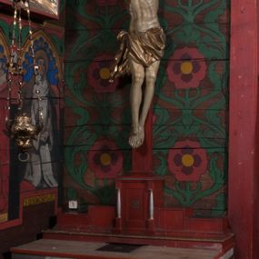 Zdjęcie nr 1: Struktura złożona z ołtarza i krucyfiksu na podstawie. Ołtarz drewniany, prostopadłościenny, z kamienną mensą i marmurowym portatylem. Ścianki ołtarza wypełnione płycinami dekorowanymi u dołu i u góry spłaszczonym fryzem arkadkowym, w polu antepedium motyw krzyża ujętego czworoliściem. Podstawa dla krzyża schodkowa. Pośrodku niej znajduje się tabernakulum w formie skrzynki, flankowanej parą półkolumienek na cokołach. Jego drzwiczki przyjmują kształt stojącego prostokąta z płyciną i malowanym wieńcem z krzyżem w polu. Krzyż z figurą Chrystusa o prostym zakończeniu ramion. Struktura i krzyż polichromowane w jasnobrązowym kolorze z pozłacanymi i posrebrzanymi detalami. 
