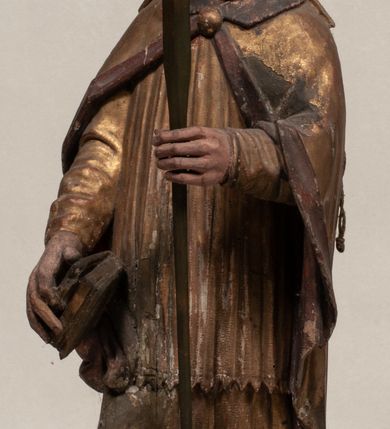 Zdjęcie nr 1: Figura nieopracowana z tyłu, ustawiona na niewielkiej podstawie. Święty ukazany jest w całej postaci, frontalnie, w kontrapoście, z pochyloną głową skierowaną w lewo. W prawej, opuszczonej wzdłuż ciała ręce trzyma zamkniętą księgę, w lewej, uniesionej przed sobą na wysokości piersi – wiosło. Jego twarz jest trójkątna o migdałowatych oczach, krótkim nosie i wąskich ustach, okolona brodą. Ubrany jest w albę, rokietę oraz płaszcz z kołnierzem zapięty pod szyją, na głowie ma infułę. Polichromia naturalistyczna w partiach ciała, strój i atrybuty złocone. 

