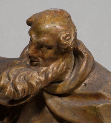 Zdjęcie nr 4: Rzeźba pełnoplastyczna, zwrócona jest frontalnie, w kontrapoście, łukowato przegięta w lewo. Święty lewą ręką trzyma przy boku zamkniętą księgą, w prawej zaś odwrócony dzban, z którego wylewa się woda. Jego twarz jest szczupła, o głęboko osadzonych oczach, dużym, krótkim nosie i pełnych rozchylonych ustach, okolona długą, gęstą brodą, silnie wysuniętą do przodu oraz kręconymi włosami po bokach głowy. Prorok jest ubrany w silnie drapowany habit przewiązany w pasie, ze szkaplerzem oraz płaszcz z kapturem zapięty pod szyją, opadający na ramiona, z zawiniętą przy lewym boku partią ekspresyjnie rozwianej tkaniny. Figura w całości pozłocona. 





