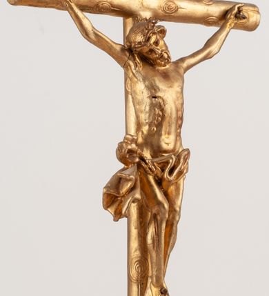 Zdjęcie nr 4: Grupa Ukrzyżowania umieszczona jest na wysokim cokole z ryzalitem pośrodku, profilowanym u dołu i zakończonym gzymsem z kostkowaniem. Do cokołu z trzech stron przytwierdzone są gwoździkami płaskorzeźbione narzędzia Męki Pańskiej. Grupa ustawiona jest na rzeźbionym podłożu imitującym skałę. Pośrodku znajduje się krzyż z pnia drzewa, do którego przybita jest trzema gwoździami figurka umarłego Chrystusa. Jego ciało jest w dużym zwisie, o ramionach przyjmujących kształt łuku półkolistego, głowa opada na prawy bark, nogi ułożone są równolegle, stopy skrzyżowane w układzie prawa na lewą. Twarz pociągła, okolona krótką brodą oraz silnie kręconymi włosami, na głowie korona cierniowa. Ciało smukłe, z podkreślonymi żebrami klatki piersiowej i zaznaczonymi śladami męki. Biodra przepasane krótkim, ekspresyjnie drapowanym perizonium, zawieszonym na podwójnym sznurze, odsłaniającym prawe biodro, zawiązanym na prawym boku. Pionowa belka krzyża zakończona banderolą z rytym napisem „IN / RI”. U podstawy krzyża znajduje się czaszka z piszczelami. 
Po prawej stronie krzyża stoi Maria ze splecionymi z przodu dłońmi. Ubrana jest w tunikę, przepasaną w talii oraz płaszcz narzucony na głowę i ramiona. Po lewej stronie znajduje się św. Jan. Zwrócony jest w trzech czwartych w prawo, klęczy na prawym kolanie i prawą dłoń kładzie na piersi, lewą rękę wyciąga do przodu. Jego twarz okalają długie włosy opadające na ramiona. Ubrany jest w tunikę, przepasaną w talii. 
Figury oraz detale rzeźbiarskie i profile cokołu pozłocone, struktura cokołu polichromowana na czarno. 