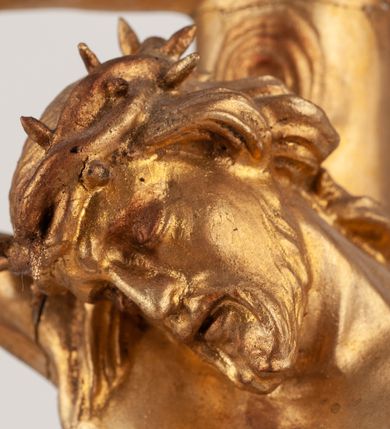 Zdjęcie nr 8: Grupa Ukrzyżowania umieszczona jest na wysokim cokole z ryzalitem pośrodku, profilowanym u dołu i zakończonym gzymsem z kostkowaniem. Do cokołu z trzech stron przytwierdzone są gwoździkami płaskorzeźbione narzędzia Męki Pańskiej. Grupa ustawiona jest na rzeźbionym podłożu imitującym skałę. Pośrodku znajduje się krzyż z pnia drzewa, do którego przybita jest trzema gwoździami figurka umarłego Chrystusa. Jego ciało jest w dużym zwisie, o ramionach przyjmujących kształt łuku półkolistego, głowa opada na prawy bark, nogi ułożone są równolegle, stopy skrzyżowane w układzie prawa na lewą. Twarz pociągła, okolona krótką brodą oraz silnie kręconymi włosami, na głowie korona cierniowa. Ciało smukłe, z podkreślonymi żebrami klatki piersiowej i zaznaczonymi śladami męki. Biodra przepasane krótkim, ekspresyjnie drapowanym perizonium, zawieszonym na podwójnym sznurze, odsłaniającym prawe biodro, zawiązanym na prawym boku. Pionowa belka krzyża zakończona banderolą z rytym napisem „IN / RI”. U podstawy krzyża znajduje się czaszka z piszczelami. 
Po prawej stronie krzyża stoi Maria ze splecionymi z przodu dłońmi. Ubrana jest w tunikę, przepasaną w talii oraz płaszcz narzucony na głowę i ramiona. Po lewej stronie znajduje się św. Jan. Zwrócony jest w trzech czwartych w prawo, klęczy na prawym kolanie i prawą dłoń kładzie na piersi, lewą rękę wyciąga do przodu. Jego twarz okalają długie włosy opadające na ramiona. Ubrany jest w tunikę, przepasaną w talii. 
Figury oraz detale rzeźbiarskie i profile cokołu pozłocone, struktura cokołu polichromowana na czarno. 