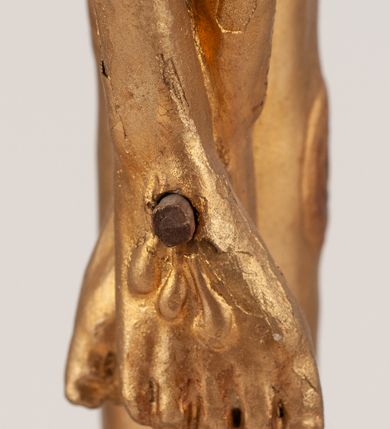 Zdjęcie nr 9: Grupa Ukrzyżowania umieszczona jest na wysokim cokole z ryzalitem pośrodku, profilowanym u dołu i zakończonym gzymsem z kostkowaniem. Do cokołu z trzech stron przytwierdzone są gwoździkami płaskorzeźbione narzędzia Męki Pańskiej. Grupa ustawiona jest na rzeźbionym podłożu imitującym skałę. Pośrodku znajduje się krzyż z pnia drzewa, do którego przybita jest trzema gwoździami figurka umarłego Chrystusa. Jego ciało jest w dużym zwisie, o ramionach przyjmujących kształt łuku półkolistego, głowa opada na prawy bark, nogi ułożone są równolegle, stopy skrzyżowane w układzie prawa na lewą. Twarz pociągła, okolona krótką brodą oraz silnie kręconymi włosami, na głowie korona cierniowa. Ciało smukłe, z podkreślonymi żebrami klatki piersiowej i zaznaczonymi śladami męki. Biodra przepasane krótkim, ekspresyjnie drapowanym perizonium, zawieszonym na podwójnym sznurze, odsłaniającym prawe biodro, zawiązanym na prawym boku. Pionowa belka krzyża zakończona banderolą z rytym napisem „IN / RI”. U podstawy krzyża znajduje się czaszka z piszczelami. 
Po prawej stronie krzyża stoi Maria ze splecionymi z przodu dłońmi. Ubrana jest w tunikę, przepasaną w talii oraz płaszcz narzucony na głowę i ramiona. Po lewej stronie znajduje się św. Jan. Zwrócony jest w trzech czwartych w prawo, klęczy na prawym kolanie i prawą dłoń kładzie na piersi, lewą rękę wyciąga do przodu. Jego twarz okalają długie włosy opadające na ramiona. Ubrany jest w tunikę, przepasaną w talii. 
Figury oraz detale rzeźbiarskie i profile cokołu pozłocone, struktura cokołu polichromowana na czarno. 