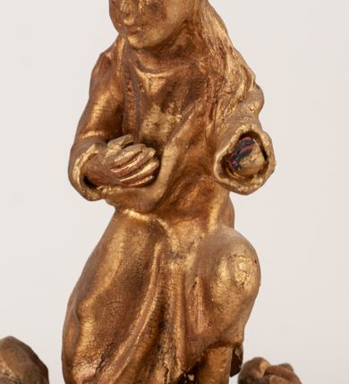 Zdjęcie nr 18: Grupa Ukrzyżowania umieszczona jest na wysokim cokole z ryzalitem pośrodku, profilowanym u dołu i zakończonym gzymsem z kostkowaniem. Do cokołu z trzech stron przytwierdzone są gwoździkami płaskorzeźbione narzędzia Męki Pańskiej. Grupa ustawiona jest na rzeźbionym podłożu imitującym skałę. Pośrodku znajduje się krzyż z pnia drzewa, do którego przybita jest trzema gwoździami figurka umarłego Chrystusa. Jego ciało jest w dużym zwisie, o ramionach przyjmujących kształt łuku półkolistego, głowa opada na prawy bark, nogi ułożone są równolegle, stopy skrzyżowane w układzie prawa na lewą. Twarz pociągła, okolona krótką brodą oraz silnie kręconymi włosami, na głowie korona cierniowa. Ciało smukłe, z podkreślonymi żebrami klatki piersiowej i zaznaczonymi śladami męki. Biodra przepasane krótkim, ekspresyjnie drapowanym perizonium, zawieszonym na podwójnym sznurze, odsłaniającym prawe biodro, zawiązanym na prawym boku. Pionowa belka krzyża zakończona banderolą z rytym napisem „IN / RI”. U podstawy krzyża znajduje się czaszka z piszczelami. 
Po prawej stronie krzyża stoi Maria ze splecionymi z przodu dłońmi. Ubrana jest w tunikę, przepasaną w talii oraz płaszcz narzucony na głowę i ramiona. Po lewej stronie znajduje się św. Jan. Zwrócony jest w trzech czwartych w prawo, klęczy na prawym kolanie i prawą dłoń kładzie na piersi, lewą rękę wyciąga do przodu. Jego twarz okalają długie włosy opadające na ramiona. Ubrany jest w tunikę, przepasaną w talii. 
Figury oraz detale rzeźbiarskie i profile cokołu pozłocone, struktura cokołu polichromowana na czarno. 