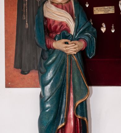 Zdjęcie nr 2: Rzeźba przedstawia Chrystusa Ukrzyżowanego. Postać ukazana jest frontalnie, przybita do krzyża trzema gwoździami z nogami delikatnie ugiętymi w kolanach. Głowa Chrystusa opada na prawe ramię. Sylwetka muskularna z wyraźnie podkreśloną linią żeber i mostka w formie guzów. Twarz podłużna z zamkniętymi oczami, długim i prostym nosem, okolona ciemnobrązową brodą, zwiniętą na końcu w dwa symetryczne pukle. Długie, brązowe włosy opadają na plecy i jednym puklem na prawe ramię. Na głowie Chrystus ma założoną zieloną koronę cierniową. Na prawym boku widać krwawiącą ranę. Podobnie smużki krwi wypływają z ran po gwoździach. Perizonium złocone, przewiązane na prawym boku sznurem i zwisające wzdłuż prawego biodra. W górnej części krzyża znajduje się titulus w formie pionowej banderoli z napisem „IN/RI”. Polichromia w odsłoniętych partiach ciała naturalistyczna. Perizonium i titulus złocone. Krzyż prosty i gładki, malowany na brązowo.

