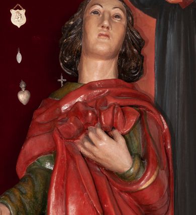 Zdjęcie nr 8: Rzeźba przedstawia Chrystusa Ukrzyżowanego. Postać ukazana jest frontalnie, przybita do krzyża trzema gwoździami z nogami delikatnie ugiętymi w kolanach. Głowa Chrystusa opada na prawe ramię. Sylwetka muskularna z wyraźnie podkreśloną linią żeber i mostka w formie guzów. Twarz podłużna z zamkniętymi oczami, długim i prostym nosem, okolona ciemnobrązową brodą, zwiniętą na końcu w dwa symetryczne pukle. Długie, brązowe włosy opadają na plecy i jednym puklem na prawe ramię. Na głowie Chrystus ma założoną zieloną koronę cierniową. Na prawym boku widać krwawiącą ranę. Podobnie smużki krwi wypływają z ran po gwoździach. Perizonium złocone, przewiązane na prawym boku sznurem i zwisające wzdłuż prawego biodra. W górnej części krzyża znajduje się titulus w formie pionowej banderoli z napisem „IN/RI”. Polichromia w odsłoniętych partiach ciała naturalistyczna. Perizonium i titulus złocone. Krzyż prosty i gładki, malowany na brązowo.

