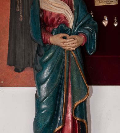 Zdjęcie nr 1: Rzeźba pełnoplastyczna, ustawiona na niskim cokole. Matka Boska stojąca w nieznacznym kontrapoście z dłońmi splecionymi na wysokości pasa oraz głową uniesioną ku górze. Twarz pociągła, nos długi i prosty, małe usta, wzrok skierowany ku górze. Ubrana jest w czerwoną suknię z długimi rękawami, ze złotą lamówką u szyi oraz swobodnie narzucony na ramiona błękitny płaszcz ozdobiony na brzegach analogicznym wykończeniem jak w sukni. Na głowie ma założony biały welon, którego jeden koniec spływa z przodu postaci. Spod szat wystają bose stopy. Polichromia w odsłoniętych partiach ciała naturalistyczna, delikatnie jasna.