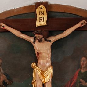 Zdjęcie nr 1: Pełnoplastyczna figura Chrystusa na prostym krzyżu umieszczona na tle malowanego przedstawienia grupy Ukrzyżowania z Marią, św. Janem i z Jerozolimą pośrodku. Rzeźba Chrystusa przybita do krzyża trzema gwoździami, ukazana w typie Cristo morto. Ciało w delikatnym zwisie, sylwetka wydłużona o delikatnie podkreślonej anatomii, nogi lekko ugięte w kolanach. Chrystus ma głowę przechyloną na prawe ramię. Twarz szczupła, z wąskim i długim nosem, zamkniętymi oczami, na wpół otwartymi ustami, okolona krótką brodą, rozdzieloną na końcu w dwa pukle. Włosy długie, spływające na ramiona dwoma skręconymi lokami, na głowie założona korona cierniowa. Perizonium zawiązane na węzeł na prawym boku, z jednym końcem zwisającym wzdłuż prawej nogi, z przodu tworzące fałdy na kształt litery „V”. Z boku, dłoni, stóp i spod korony cierniowej spływają strużki krwi. Polichromia ciała naturalistyczna, perizonium i titulus złocone. Krzyż gładki, nad głową Chrystusa titulus w formie pionowej banderoli z napisem „I.N./R.I.”. 
