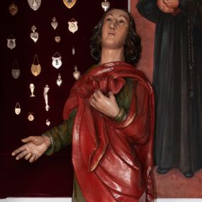 Zdjęcie nr 1: Pełnoplastyczna, polichromowana figura św. Jana ustawiona na niewielkim cokole. Święty ukazany w delikatnym kontrapoście z lewą nogą ugiętą w kolanie, głową uniesioną do góry. Prawą rękę ma wyciągniętą w bok, lewą złożoną na piersi podtrzymuje udrapowaną połę płaszcza. Święty o młodzieńczej fizjonomii, z długimi rozwianymi włosami skręcającymi się w bujne loki po bokach. Twarz pozbawiona zarostu, oczy skierowane ku górze, półkoliste łuki brwiowe. Ubrany jest  w długą, zieloną suknię opadającą prostymi fałdami oraz czerwony płaszcz zarzucony na ramiona, udrapowany na piersi, zawinięty pod lewą ręką. Spod szat wystają bose stopy. Polichromia w odsłoniętych partiach ciała naturalistyczna.