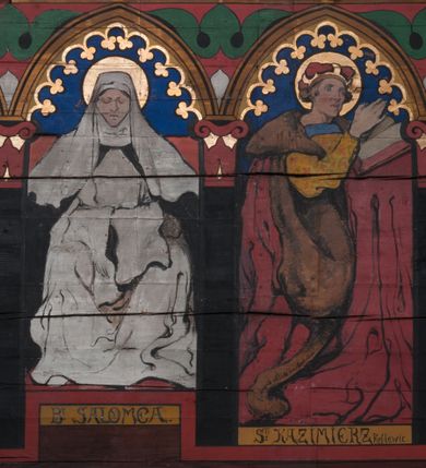 Zdjęcie nr 29: Polichromia o charakterze figuralnym i geometryczno-roślinnym pokrywa ściany i sklepienia prezbiterium, nawy, zakrystii i kruchty zachodniej. Wszystkie ściany prezbiterium do wysokości gzymsu dekorowane są pionowymi, układającymi się naprzemiennie pasami ornamentu roślinno-geometrycznego. Jeden z nich jest granatowy o motywie złotych liści dębu układających się w rozetę z ornamentem geometrycznym. Drugi pas jest żółty z motywem stylizowanych fioletowych i różowych kwiatów o zgeometryzowanych detalach. Gzyms prezbiterium i nawy w kolorze czerwonym, na nim złoty geometryczny pas oraz ornament z granatowych falistych linii wypełnionych w środku białymi punktami. 
Sklepienie prezbiterium jest niebieskie, obramione żółtym pasem z zieloną wicią roślinną, na której ułożone są naprzemiennie granatowe i różowe kwiaty. W narożach stylizowane bukiety kwiatów w kolorach zieleni, brązu i żółci. W centrum sklepienia okrągły medalion ze św. Kingą i Bolesławem Wstydliwym na tle pejzażu wielickiego z kościołem i zamkiem żupnym w oddali. Na pierwszym planie św. Kinga zwrócona jest w swoją prawą stronę, z uniesioną głową. W lewej ręce trzyma pastorał, w prawej wyciągniętej pierścień. Święta ubrana jest w czarny habit klaryski ze szkaplerzem, białą podwiką i welonem oraz czarnym płaszczem z czerwoną podszewką. Na piersi ma złoty łańcuch, na głowie mitrę książęcą. Po prawej stronie św. Kingi klęczy Bolesław Wstydliwy, który obiema rękami trzyma przy rękojeści wbity w ziemię miecz, opleciony skórzanym pasem. Książę ubrany jest w zbroję, niebieską tunikę i czerwony płaszcz spięty złotą fibulą. Na głowie ma kaptur kolczy i hełm z otwartą koroną. Medalion ze sceną ujęty jest żółtą ramą wypełnioną stylizowaną wicią roślinną z naprzemiennie występującymi granatowymi i różowymi kwiatami. Krawędź zewnętrza ozdobiona srebrzystym wieńcem z naprzemiennie ułożonego trójliścia i płomyka. 
Wszystkie ściany nawy pokryte są stylizowanym ornamentem roślinnym składającym się z zielonej wici roślinnej układającej się w regularne medaliony, w których znajdują się kwiaty czerwonego maku. 
Na ścianie północnej w dolnym pasie, pod oknem sześć ostrołukowych arkad na stylizowanych kolumienkach. W pierwszej arkadzie od strony prezbiterium postać klęczącej zakonnicy z opuszczonymi, splecionymi dłońmi, która ubrana jest w biały habit norbertański ze szkaplerzem i brązowy płaszcz z kapturem. U dołu w żółtym polu napis „S(wię)ta BRONISŁAWA”. W drugiej arkadzie królewicz klęczący przy pulpicie, zwrócony w stronę prezbiterium, w obszernym czerwonym płaszczu podbitym futrem i mitrze na głowie. U dołu w żółtym polu napis „S(wię)ty KAZIMIERZ Królewic(z)” W trzeciej arkadzie zwrócona frontalnie siedząca postać z pochyloną głową, ubrana w biały habit zakonny z czarnym płaszczem. U dołu w żółtym polu napis „Bł(ogosławiona) SALOMEA”. W następnych dwóch arkadach występuje stylizowany ornament roślinny z czterema rozetami i ze srebrnym orłem z dwiema tarczami herbowymi, pierwsza z krzyżem na piersi, druga z herbem Szreniawa poniżej. Pole szóstej arkady bez dekoracji. 
Na ścianie południowej w dolnym pasie, pod oknem trzy analogiczne arkady. W pierwszej arkadzie od strony prezbiterium frontalnie siedząca postać w stroju biskupa: białej albie, ciemnoróżowej komży z żółtą lamówką, żółtej kapie i paliuszu, na głowie ma infułę. U dołu w żółtym polu napis „Bł(ogosławiony) WINC(ENTY) KADŁUBEK”. W drugiej arkadzie  postać ukazana w pozycji stojącej, zwróconej w stronę prezbiterium, w prawej ręce trzyma pastorał, lewa w geście błogosławieństwa, ubrana w analogiczny jak poprzednia strój biskupi. U dołu w żółtym polu napis „S(wię)ty STANISŁAW SZCZEP(ANOWSKI)”. W trzeciej arkadzie frontalnie siedząca postać w stroju biskupa: ciemnoróżowej albie, żółtym ornacie, paliuszu, na głowie ma infułę. W  prawej ręce trzyma pastorał, w lewej miniaturę kościoła Mariackiego w Krakowie. Pod nim napis „Bł(ogosławiony) IVO ODROWĄŻ”. 
Sklepienie nawy ujęte ramą złożoną z kilku pasów. Zewnętrzny podzielony na kwadratowe pola, w których naprzemiennie występują dekoracyjny krzyż z kaboszonami i splecionymi literami „MS” oraz wpisany w koło czworoliść z trzema kilofami. Wewnętrzny pas jest zielony dekorowany srebrzonymi kołami, wydzielony zieloną i żółtą falowaną wstęgą. Pośrodku wschodniego pasa obramienia, przy łuku tęczowym znajduje się srebrzony orzeł z tarczą herbową z krzyżem na piersi i tarczą z herbem Szreniawa u dołu. W szponach trzyma trzy kilofy oraz wagę. U dołu znajduje się wstęga z napisem „Arma regiae liberae montanaequae / civitatis Vielicensis”. 
W centrum sklepienia nawy medalion ujęty zewnętrzną ramą utworzoną z grotów i płomieni oraz wewnętrzną z przeplatających się spiralnie wici roślinnych. W polu przedstawienie męczeństwa św. Sebastiana. Postać zwrócona w trzech czwartych w lewo, o bezwładnie opadającym ciele przywiązanym za ramiona i ugięte nogi do drzewa. Wokół głowy nimb zamknięty. Święty przesłonięty w partii podbrzusza białą draperią opadającą na ziemię, po bokach postaci. Ciało wychudzone, o podkreślonej muskulaturze, ze strzałą wbitą w pierś. Święty ukazany na tle lasu, w nocy. W narożach i na osiach sklepienia nawy bukiety kwiatów utworzonych z maków, habrów, kaczeńców i kłosów zbóż. 
W zakrystii na sklepieniu niewielkie Oko Opatrzności w glorii promienistej oraz falista bordiura. Analogiczna bordiura w kruchcie zachodniej. W południowo-zachodnim narożu kruchty północnej malowany na czarno krzyż oraz obok wyryty w drewnie napis: „BI 1898”. W dolnej partii ściany północnej przy chórze muzycznym sygnatura „Włodzimierz Tetmajer pinxit. A(NNO) D(OMINI) MCMVI.”