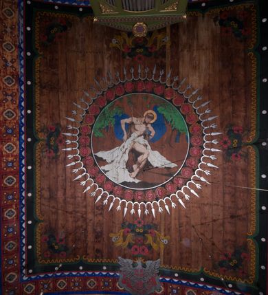 Zdjęcie nr 20: Polichromia o charakterze figuralnym i geometryczno-roślinnym pokrywa ściany i sklepienia prezbiterium, nawy, zakrystii i kruchty zachodniej. Wszystkie ściany prezbiterium do wysokości gzymsu dekorowane są pionowymi, układającymi się naprzemiennie pasami ornamentu roślinno-geometrycznego. Jeden z nich jest granatowy o motywie złotych liści dębu układających się w rozetę z ornamentem geometrycznym. Drugi pas jest żółty z motywem stylizowanych fioletowych i różowych kwiatów o zgeometryzowanych detalach. Gzyms prezbiterium i nawy w kolorze czerwonym, na nim złoty geometryczny pas oraz ornament z granatowych falistych linii wypełnionych w środku białymi punktami. 
Sklepienie prezbiterium jest niebieskie, obramione żółtym pasem z zieloną wicią roślinną, na której ułożone są naprzemiennie granatowe i różowe kwiaty. W narożach stylizowane bukiety kwiatów w kolorach zieleni, brązu i żółci. W centrum sklepienia okrągły medalion ze św. Kingą i Bolesławem Wstydliwym na tle pejzażu wielickiego z kościołem i zamkiem żupnym w oddali. Na pierwszym planie św. Kinga zwrócona jest w swoją prawą stronę, z uniesioną głową. W lewej ręce trzyma pastorał, w prawej wyciągniętej pierścień. Święta ubrana jest w czarny habit klaryski ze szkaplerzem, białą podwiką i welonem oraz czarnym płaszczem z czerwoną podszewką. Na piersi ma złoty łańcuch, na głowie mitrę książęcą. Po prawej stronie św. Kingi klęczy Bolesław Wstydliwy, który obiema rękami trzyma przy rękojeści wbity w ziemię miecz, opleciony skórzanym pasem. Książę ubrany jest w zbroję, niebieską tunikę i czerwony płaszcz spięty złotą fibulą. Na głowie ma kaptur kolczy i hełm z otwartą koroną. Medalion ze sceną ujęty jest żółtą ramą wypełnioną stylizowaną wicią roślinną z naprzemiennie występującymi granatowymi i różowymi kwiatami. Krawędź zewnętrza ozdobiona srebrzystym wieńcem z naprzemiennie ułożonego trójliścia i płomyka. 
Wszystkie ściany nawy pokryte są stylizowanym ornamentem roślinnym składającym się z zielonej wici roślinnej układającej się w regularne medaliony, w których znajdują się kwiaty czerwonego maku. 
Na ścianie północnej w dolnym pasie, pod oknem sześć ostrołukowych arkad na stylizowanych kolumienkach. W pierwszej arkadzie od strony prezbiterium postać klęczącej zakonnicy z opuszczonymi, splecionymi dłońmi, która ubrana jest w biały habit norbertański ze szkaplerzem i brązowy płaszcz z kapturem. U dołu w żółtym polu napis „S(wię)ta BRONISŁAWA”. W drugiej arkadzie królewicz klęczący przy pulpicie, zwrócony w stronę prezbiterium, w obszernym czerwonym płaszczu podbitym futrem i mitrze na głowie. U dołu w żółtym polu napis „S(wię)ty KAZIMIERZ Królewic(z)” W trzeciej arkadzie zwrócona frontalnie siedząca postać z pochyloną głową, ubrana w biały habit zakonny z czarnym płaszczem. U dołu w żółtym polu napis „Bł(ogosławiona) SALOMEA”. W następnych dwóch arkadach występuje stylizowany ornament roślinny z czterema rozetami i ze srebrnym orłem z dwiema tarczami herbowymi, pierwsza z krzyżem na piersi, druga z herbem Szreniawa poniżej. Pole szóstej arkady bez dekoracji. 
Na ścianie południowej w dolnym pasie, pod oknem trzy analogiczne arkady. W pierwszej arkadzie od strony prezbiterium frontalnie siedząca postać w stroju biskupa: białej albie, ciemnoróżowej komży z żółtą lamówką, żółtej kapie i paliuszu, na głowie ma infułę. U dołu w żółtym polu napis „Bł(ogosławiony) WINC(ENTY) KADŁUBEK”. W drugiej arkadzie  postać ukazana w pozycji stojącej, zwróconej w stronę prezbiterium, w prawej ręce trzyma pastorał, lewa w geście błogosławieństwa, ubrana w analogiczny jak poprzednia strój biskupi. U dołu w żółtym polu napis „S(wię)ty STANISŁAW SZCZEP(ANOWSKI)”. W trzeciej arkadzie frontalnie siedząca postać w stroju biskupa: ciemnoróżowej albie, żółtym ornacie, paliuszu, na głowie ma infułę. W  prawej ręce trzyma pastorał, w lewej miniaturę kościoła Mariackiego w Krakowie. Pod nim napis „Bł(ogosławiony) IVO ODROWĄŻ”. 
Sklepienie nawy ujęte ramą złożoną z kilku pasów. Zewnętrzny podzielony na kwadratowe pola, w których naprzemiennie występują dekoracyjny krzyż z kaboszonami i splecionymi literami „MS” oraz wpisany w koło czworoliść z trzema kilofami. Wewnętrzny pas jest zielony dekorowany srebrzonymi kołami, wydzielony zieloną i żółtą falowaną wstęgą. Pośrodku wschodniego pasa obramienia, przy łuku tęczowym znajduje się srebrzony orzeł z tarczą herbową z krzyżem na piersi i tarczą z herbem Szreniawa u dołu. W szponach trzyma trzy kilofy oraz wagę. U dołu znajduje się wstęga z napisem „Arma regiae liberae montanaequae / civitatis Vielicensis”. 
W centrum sklepienia nawy medalion ujęty zewnętrzną ramą utworzoną z grotów i płomieni oraz wewnętrzną z przeplatających się spiralnie wici roślinnych. W polu przedstawienie męczeństwa św. Sebastiana. Postać zwrócona w trzech czwartych w lewo, o bezwładnie opadającym ciele przywiązanym za ramiona i ugięte nogi do drzewa. Wokół głowy nimb zamknięty. Święty przesłonięty w partii podbrzusza białą draperią opadającą na ziemię, po bokach postaci. Ciało wychudzone, o podkreślonej muskulaturze, ze strzałą wbitą w pierś. Święty ukazany na tle lasu, w nocy. W narożach i na osiach sklepienia nawy bukiety kwiatów utworzonych z maków, habrów, kaczeńców i kłosów zbóż. 
W zakrystii na sklepieniu niewielkie Oko Opatrzności w glorii promienistej oraz falista bordiura. Analogiczna bordiura w kruchcie zachodniej. W południowo-zachodnim narożu kruchty północnej malowany na czarno krzyż oraz obok wyryty w drewnie napis: „BI 1898”. W dolnej partii ściany północnej przy chórze muzycznym sygnatura „Włodzimierz Tetmajer pinxit. A(NNO) D(OMINI) MCMVI.”