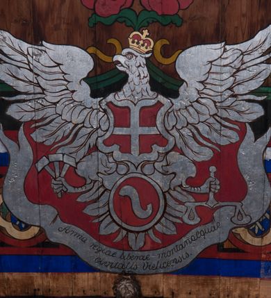 Zdjęcie nr 42: Polichromia o charakterze figuralnym i geometryczno-roślinnym pokrywa ściany i sklepienia prezbiterium, nawy, zakrystii i kruchty zachodniej. Wszystkie ściany prezbiterium do wysokości gzymsu dekorowane są pionowymi, układającymi się naprzemiennie pasami ornamentu roślinno-geometrycznego. Jeden z nich jest granatowy o motywie złotych liści dębu układających się w rozetę z ornamentem geometrycznym. Drugi pas jest żółty z motywem stylizowanych fioletowych i różowych kwiatów o zgeometryzowanych detalach. Gzyms prezbiterium i nawy w kolorze czerwonym, na nim złoty geometryczny pas oraz ornament z granatowych falistych linii wypełnionych w środku białymi punktami. 
Sklepienie prezbiterium jest niebieskie, obramione żółtym pasem z zieloną wicią roślinną, na której ułożone są naprzemiennie granatowe i różowe kwiaty. W narożach stylizowane bukiety kwiatów w kolorach zieleni, brązu i żółci. W centrum sklepienia okrągły medalion ze św. Kingą i Bolesławem Wstydliwym na tle pejzażu wielickiego z kościołem i zamkiem żupnym w oddali. Na pierwszym planie św. Kinga zwrócona jest w swoją prawą stronę, z uniesioną głową. W lewej ręce trzyma pastorał, w prawej wyciągniętej pierścień. Święta ubrana jest w czarny habit klaryski ze szkaplerzem, białą podwiką i welonem oraz czarnym płaszczem z czerwoną podszewką. Na piersi ma złoty łańcuch, na głowie mitrę książęcą. Po prawej stronie św. Kingi klęczy Bolesław Wstydliwy, który obiema rękami trzyma przy rękojeści wbity w ziemię miecz, opleciony skórzanym pasem. Książę ubrany jest w zbroję, niebieską tunikę i czerwony płaszcz spięty złotą fibulą. Na głowie ma kaptur kolczy i hełm z otwartą koroną. Medalion ze sceną ujęty jest żółtą ramą wypełnioną stylizowaną wicią roślinną z naprzemiennie występującymi granatowymi i różowymi kwiatami. Krawędź zewnętrza ozdobiona srebrzystym wieńcem z naprzemiennie ułożonego trójliścia i płomyka. 
Wszystkie ściany nawy pokryte są stylizowanym ornamentem roślinnym składającym się z zielonej wici roślinnej układającej się w regularne medaliony, w których znajdują się kwiaty czerwonego maku. 
Na ścianie północnej w dolnym pasie, pod oknem sześć ostrołukowych arkad na stylizowanych kolumienkach. W pierwszej arkadzie od strony prezbiterium postać klęczącej zakonnicy z opuszczonymi, splecionymi dłońmi, która ubrana jest w biały habit norbertański ze szkaplerzem i brązowy płaszcz z kapturem. U dołu w żółtym polu napis „S(wię)ta BRONISŁAWA”. W drugiej arkadzie królewicz klęczący przy pulpicie, zwrócony w stronę prezbiterium, w obszernym czerwonym płaszczu podbitym futrem i mitrze na głowie. U dołu w żółtym polu napis „S(wię)ty KAZIMIERZ Królewic(z)” W trzeciej arkadzie zwrócona frontalnie siedząca postać z pochyloną głową, ubrana w biały habit zakonny z czarnym płaszczem. U dołu w żółtym polu napis „Bł(ogosławiona) SALOMEA”. W następnych dwóch arkadach występuje stylizowany ornament roślinny z czterema rozetami i ze srebrnym orłem z dwiema tarczami herbowymi, pierwsza z krzyżem na piersi, druga z herbem Szreniawa poniżej. Pole szóstej arkady bez dekoracji. 
Na ścianie południowej w dolnym pasie, pod oknem trzy analogiczne arkady. W pierwszej arkadzie od strony prezbiterium frontalnie siedząca postać w stroju biskupa: białej albie, ciemnoróżowej komży z żółtą lamówką, żółtej kapie i paliuszu, na głowie ma infułę. U dołu w żółtym polu napis „Bł(ogosławiony) WINC(ENTY) KADŁUBEK”. W drugiej arkadzie  postać ukazana w pozycji stojącej, zwróconej w stronę prezbiterium, w prawej ręce trzyma pastorał, lewa w geście błogosławieństwa, ubrana w analogiczny jak poprzednia strój biskupi. U dołu w żółtym polu napis „S(wię)ty STANISŁAW SZCZEP(ANOWSKI)”. W trzeciej arkadzie frontalnie siedząca postać w stroju biskupa: ciemnoróżowej albie, żółtym ornacie, paliuszu, na głowie ma infułę. W  prawej ręce trzyma pastorał, w lewej miniaturę kościoła Mariackiego w Krakowie. Pod nim napis „Bł(ogosławiony) IVO ODROWĄŻ”. 
Sklepienie nawy ujęte ramą złożoną z kilku pasów. Zewnętrzny podzielony na kwadratowe pola, w których naprzemiennie występują dekoracyjny krzyż z kaboszonami i splecionymi literami „MS” oraz wpisany w koło czworoliść z trzema kilofami. Wewnętrzny pas jest zielony dekorowany srebrzonymi kołami, wydzielony zieloną i żółtą falowaną wstęgą. Pośrodku wschodniego pasa obramienia, przy łuku tęczowym znajduje się srebrzony orzeł z tarczą herbową z krzyżem na piersi i tarczą z herbem Szreniawa u dołu. W szponach trzyma trzy kilofy oraz wagę. U dołu znajduje się wstęga z napisem „Arma regiae liberae montanaequae / civitatis Vielicensis”. 
W centrum sklepienia nawy medalion ujęty zewnętrzną ramą utworzoną z grotów i płomieni oraz wewnętrzną z przeplatających się spiralnie wici roślinnych. W polu przedstawienie męczeństwa św. Sebastiana. Postać zwrócona w trzech czwartych w lewo, o bezwładnie opadającym ciele przywiązanym za ramiona i ugięte nogi do drzewa. Wokół głowy nimb zamknięty. Święty przesłonięty w partii podbrzusza białą draperią opadającą na ziemię, po bokach postaci. Ciało wychudzone, o podkreślonej muskulaturze, ze strzałą wbitą w pierś. Święty ukazany na tle lasu, w nocy. W narożach i na osiach sklepienia nawy bukiety kwiatów utworzonych z maków, habrów, kaczeńców i kłosów zbóż. 
W zakrystii na sklepieniu niewielkie Oko Opatrzności w glorii promienistej oraz falista bordiura. Analogiczna bordiura w kruchcie zachodniej. W południowo-zachodnim narożu kruchty północnej malowany na czarno krzyż oraz obok wyryty w drewnie napis: „BI 1898”. W dolnej partii ściany północnej przy chórze muzycznym sygnatura „Włodzimierz Tetmajer pinxit. A(NNO) D(OMINI) MCMVI.”