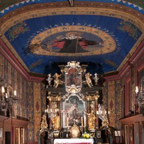 Zdjęcie nr 1: Polichromia o charakterze figuralnym i geometryczno-roślinnym pokrywa ściany i sklepienia prezbiterium, nawy, zakrystii i kruchty zachodniej. Wszystkie ściany prezbiterium do wysokości gzymsu dekorowane są pionowymi, układającymi się naprzemiennie pasami ornamentu roślinno-geometrycznego. Jeden z nich jest granatowy o motywie złotych liści dębu układających się w rozetę z ornamentem geometrycznym. Drugi pas jest żółty z motywem stylizowanych fioletowych i różowych kwiatów o zgeometryzowanych detalach. Gzyms prezbiterium i nawy w kolorze czerwonym, na nim złoty geometryczny pas oraz ornament z granatowych falistych linii wypełnionych w środku białymi punktami. 
Sklepienie prezbiterium jest niebieskie, obramione żółtym pasem z zieloną wicią roślinną, na której ułożone są naprzemiennie granatowe i różowe kwiaty. W narożach stylizowane bukiety kwiatów w kolorach zieleni, brązu i żółci. W centrum sklepienia okrągły medalion ze św. Kingą i Bolesławem Wstydliwym na tle pejzażu wielickiego z kościołem i zamkiem żupnym w oddali. Na pierwszym planie św. Kinga zwrócona jest w swoją prawą stronę, z uniesioną głową. W lewej ręce trzyma pastorał, w prawej wyciągniętej pierścień. Święta ubrana jest w czarny habit klaryski ze szkaplerzem, białą podwiką i welonem oraz czarnym płaszczem z czerwoną podszewką. Na piersi ma złoty łańcuch, na głowie mitrę książęcą. Po prawej stronie św. Kingi klęczy Bolesław Wstydliwy, który obiema rękami trzyma przy rękojeści wbity w ziemię miecz, opleciony skórzanym pasem. Książę ubrany jest w zbroję, niebieską tunikę i czerwony płaszcz spięty złotą fibulą. Na głowie ma kaptur kolczy i hełm z otwartą koroną. Medalion ze sceną ujęty jest żółtą ramą wypełnioną stylizowaną wicią roślinną z naprzemiennie występującymi granatowymi i różowymi kwiatami. Krawędź zewnętrza ozdobiona srebrzystym wieńcem z naprzemiennie ułożonego trójliścia i płomyka. 
Wszystkie ściany nawy pokryte są stylizowanym ornamentem roślinnym składającym się z zielonej wici roślinnej układającej się w regularne medaliony, w których znajdują się kwiaty czerwonego maku. 
Na ścianie północnej w dolnym pasie, pod oknem sześć ostrołukowych arkad na stylizowanych kolumienkach. W pierwszej arkadzie od strony prezbiterium postać klęczącej zakonnicy z opuszczonymi, splecionymi dłońmi, która ubrana jest w biały habit norbertański ze szkaplerzem i brązowy płaszcz z kapturem. U dołu w żółtym polu napis „S(wię)ta BRONISŁAWA”. W drugiej arkadzie królewicz klęczący przy pulpicie, zwrócony w stronę prezbiterium, w obszernym czerwonym płaszczu podbitym futrem i mitrze na głowie. U dołu w żółtym polu napis „S(wię)ty KAZIMIERZ Królewic(z)” W trzeciej arkadzie zwrócona frontalnie siedząca postać z pochyloną głową, ubrana w biały habit zakonny z czarnym płaszczem. U dołu w żółtym polu napis „Bł(ogosławiona) SALOMEA”. W następnych dwóch arkadach występuje stylizowany ornament roślinny z czterema rozetami i ze srebrnym orłem z dwiema tarczami herbowymi, pierwsza z krzyżem na piersi, druga z herbem Szreniawa poniżej. Pole szóstej arkady bez dekoracji. 
Na ścianie południowej w dolnym pasie, pod oknem trzy analogiczne arkady. W pierwszej arkadzie od strony prezbiterium frontalnie siedząca postać w stroju biskupa: białej albie, ciemnoróżowej komży z żółtą lamówką, żółtej kapie i paliuszu, na głowie ma infułę. U dołu w żółtym polu napis „Bł(ogosławiony) WINC(ENTY) KADŁUBEK”. W drugiej arkadzie  postać ukazana w pozycji stojącej, zwróconej w stronę prezbiterium, w prawej ręce trzyma pastorał, lewa w geście błogosławieństwa, ubrana w analogiczny jak poprzednia strój biskupi. U dołu w żółtym polu napis „S(wię)ty STANISŁAW SZCZEP(ANOWSKI)”. W trzeciej arkadzie frontalnie siedząca postać w stroju biskupa: ciemnoróżowej albie, żółtym ornacie, paliuszu, na głowie ma infułę. W  prawej ręce trzyma pastorał, w lewej miniaturę kościoła Mariackiego w Krakowie. Pod nim napis „Bł(ogosławiony) IVO ODROWĄŻ”. 
Sklepienie nawy ujęte ramą złożoną z kilku pasów. Zewnętrzny podzielony na kwadratowe pola, w których naprzemiennie występują dekoracyjny krzyż z kaboszonami i splecionymi literami „MS” oraz wpisany w koło czworoliść z trzema kilofami. Wewnętrzny pas jest zielony dekorowany srebrzonymi kołami, wydzielony zieloną i żółtą falowaną wstęgą. Pośrodku wschodniego pasa obramienia, przy łuku tęczowym znajduje się srebrzony orzeł z tarczą herbową z krzyżem na piersi i tarczą z herbem Szreniawa u dołu. W szponach trzyma trzy kilofy oraz wagę. U dołu znajduje się wstęga z napisem „Arma regiae liberae montanaequae / civitatis Vielicensis”. 
W centrum sklepienia nawy medalion ujęty zewnętrzną ramą utworzoną z grotów i płomieni oraz wewnętrzną z przeplatających się spiralnie wici roślinnych. W polu przedstawienie męczeństwa św. Sebastiana. Postać zwrócona w trzech czwartych w lewo, o bezwładnie opadającym ciele przywiązanym za ramiona i ugięte nogi do drzewa. Wokół głowy nimb zamknięty. Święty przesłonięty w partii podbrzusza białą draperią opadającą na ziemię, po bokach postaci. Ciało wychudzone, o podkreślonej muskulaturze, ze strzałą wbitą w pierś. Święty ukazany na tle lasu, w nocy. W narożach i na osiach sklepienia nawy bukiety kwiatów utworzonych z maków, habrów, kaczeńców i kłosów zbóż. 
W zakrystii na sklepieniu niewielkie Oko Opatrzności w glorii promienistej oraz falista bordiura. Analogiczna bordiura w kruchcie zachodniej. W południowo-zachodnim narożu kruchty północnej malowany na czarno krzyż oraz obok wyryty w drewnie napis: „BI 1898”. W dolnej partii ściany północnej przy chórze muzycznym sygnatura „Włodzimierz Tetmajer pinxit. A(NNO) D(OMINI) MCMVI.”