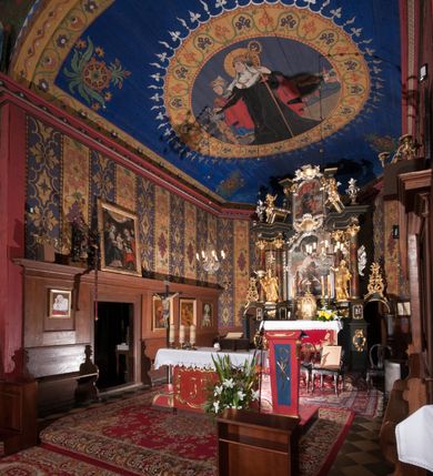 Zdjęcie nr 4: Polichromia o charakterze figuralnym i geometryczno-roślinnym pokrywa ściany i sklepienia prezbiterium, nawy, zakrystii i kruchty zachodniej. Wszystkie ściany prezbiterium do wysokości gzymsu dekorowane są pionowymi, układającymi się naprzemiennie pasami ornamentu roślinno-geometrycznego. Jeden z nich jest granatowy o motywie złotych liści dębu układających się w rozetę z ornamentem geometrycznym. Drugi pas jest żółty z motywem stylizowanych fioletowych i różowych kwiatów o zgeometryzowanych detalach. Gzyms prezbiterium i nawy w kolorze czerwonym, na nim złoty geometryczny pas oraz ornament z granatowych falistych linii wypełnionych w środku białymi punktami. 
Sklepienie prezbiterium jest niebieskie, obramione żółtym pasem z zieloną wicią roślinną, na której ułożone są naprzemiennie granatowe i różowe kwiaty. W narożach stylizowane bukiety kwiatów w kolorach zieleni, brązu i żółci. W centrum sklepienia okrągły medalion ze św. Kingą i Bolesławem Wstydliwym na tle pejzażu wielickiego z kościołem i zamkiem żupnym w oddali. Na pierwszym planie św. Kinga zwrócona jest w swoją prawą stronę, z uniesioną głową. W lewej ręce trzyma pastorał, w prawej wyciągniętej pierścień. Święta ubrana jest w czarny habit klaryski ze szkaplerzem, białą podwiką i welonem oraz czarnym płaszczem z czerwoną podszewką. Na piersi ma złoty łańcuch, na głowie mitrę książęcą. Po prawej stronie św. Kingi klęczy Bolesław Wstydliwy, który obiema rękami trzyma przy rękojeści wbity w ziemię miecz, opleciony skórzanym pasem. Książę ubrany jest w zbroję, niebieską tunikę i czerwony płaszcz spięty złotą fibulą. Na głowie ma kaptur kolczy i hełm z otwartą koroną. Medalion ze sceną ujęty jest żółtą ramą wypełnioną stylizowaną wicią roślinną z naprzemiennie występującymi granatowymi i różowymi kwiatami. Krawędź zewnętrza ozdobiona srebrzystym wieńcem z naprzemiennie ułożonego trójliścia i płomyka. 
Wszystkie ściany nawy pokryte są stylizowanym ornamentem roślinnym składającym się z zielonej wici roślinnej układającej się w regularne medaliony, w których znajdują się kwiaty czerwonego maku. 
Na ścianie północnej w dolnym pasie, pod oknem sześć ostrołukowych arkad na stylizowanych kolumienkach. W pierwszej arkadzie od strony prezbiterium postać klęczącej zakonnicy z opuszczonymi, splecionymi dłońmi, która ubrana jest w biały habit norbertański ze szkaplerzem i brązowy płaszcz z kapturem. U dołu w żółtym polu napis „S(wię)ta BRONISŁAWA”. W drugiej arkadzie królewicz klęczący przy pulpicie, zwrócony w stronę prezbiterium, w obszernym czerwonym płaszczu podbitym futrem i mitrze na głowie. U dołu w żółtym polu napis „S(wię)ty KAZIMIERZ Królewic(z)” W trzeciej arkadzie zwrócona frontalnie siedząca postać z pochyloną głową, ubrana w biały habit zakonny z czarnym płaszczem. U dołu w żółtym polu napis „Bł(ogosławiona) SALOMEA”. W następnych dwóch arkadach występuje stylizowany ornament roślinny z czterema rozetami i ze srebrnym orłem z dwiema tarczami herbowymi, pierwsza z krzyżem na piersi, druga z herbem Szreniawa poniżej. Pole szóstej arkady bez dekoracji. 
Na ścianie południowej w dolnym pasie, pod oknem trzy analogiczne arkady. W pierwszej arkadzie od strony prezbiterium frontalnie siedząca postać w stroju biskupa: białej albie, ciemnoróżowej komży z żółtą lamówką, żółtej kapie i paliuszu, na głowie ma infułę. U dołu w żółtym polu napis „Bł(ogosławiony) WINC(ENTY) KADŁUBEK”. W drugiej arkadzie  postać ukazana w pozycji stojącej, zwróconej w stronę prezbiterium, w prawej ręce trzyma pastorał, lewa w geście błogosławieństwa, ubrana w analogiczny jak poprzednia strój biskupi. U dołu w żółtym polu napis „S(wię)ty STANISŁAW SZCZEP(ANOWSKI)”. W trzeciej arkadzie frontalnie siedząca postać w stroju biskupa: ciemnoróżowej albie, żółtym ornacie, paliuszu, na głowie ma infułę. W  prawej ręce trzyma pastorał, w lewej miniaturę kościoła Mariackiego w Krakowie. Pod nim napis „Bł(ogosławiony) IVO ODROWĄŻ”. 
Sklepienie nawy ujęte ramą złożoną z kilku pasów. Zewnętrzny podzielony na kwadratowe pola, w których naprzemiennie występują dekoracyjny krzyż z kaboszonami i splecionymi literami „MS” oraz wpisany w koło czworoliść z trzema kilofami. Wewnętrzny pas jest zielony dekorowany srebrzonymi kołami, wydzielony zieloną i żółtą falowaną wstęgą. Pośrodku wschodniego pasa obramienia, przy łuku tęczowym znajduje się srebrzony orzeł z tarczą herbową z krzyżem na piersi i tarczą z herbem Szreniawa u dołu. W szponach trzyma trzy kilofy oraz wagę. U dołu znajduje się wstęga z napisem „Arma regiae liberae montanaequae / civitatis Vielicensis”. 
W centrum sklepienia nawy medalion ujęty zewnętrzną ramą utworzoną z grotów i płomieni oraz wewnętrzną z przeplatających się spiralnie wici roślinnych. W polu przedstawienie męczeństwa św. Sebastiana. Postać zwrócona w trzech czwartych w lewo, o bezwładnie opadającym ciele przywiązanym za ramiona i ugięte nogi do drzewa. Wokół głowy nimb zamknięty. Święty przesłonięty w partii podbrzusza białą draperią opadającą na ziemię, po bokach postaci. Ciało wychudzone, o podkreślonej muskulaturze, ze strzałą wbitą w pierś. Święty ukazany na tle lasu, w nocy. W narożach i na osiach sklepienia nawy bukiety kwiatów utworzonych z maków, habrów, kaczeńców i kłosów zbóż. 
W zakrystii na sklepieniu niewielkie Oko Opatrzności w glorii promienistej oraz falista bordiura. Analogiczna bordiura w kruchcie zachodniej. W południowo-zachodnim narożu kruchty północnej malowany na czarno krzyż oraz obok wyryty w drewnie napis: „BI 1898”. W dolnej partii ściany północnej przy chórze muzycznym sygnatura „Włodzimierz Tetmajer pinxit. A(NNO) D(OMINI) MCMVI.”