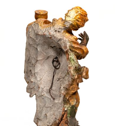 Zdjęcie nr 4: Rzeźba pełnoplastyczna, zwrócona frontalnie, ukazana w silnym kontrapoście i przegięciu ciała w prawą stronę. Święty lewą ręką podtrzymuje kielich, prawą wyciąga do przodu. Jego twarz jest okrągła o pełnych policzkach, okrągłych oczach, małym, prostym nosie, pełnych ustach i wystającej brodzie. Okolona jest długimi, silnie kręconymi włosami, opadającymi skręconymi pasmami na ramiona. Święty ubrany jest w obficie drapowaną tunikę, przylegającą do ciała w partii nóg oraz płaszcz zarzucony na plecy, z przodu postaci skręcony i zarzucony na lewe przedramię. Figura w całości pozłocona. 

