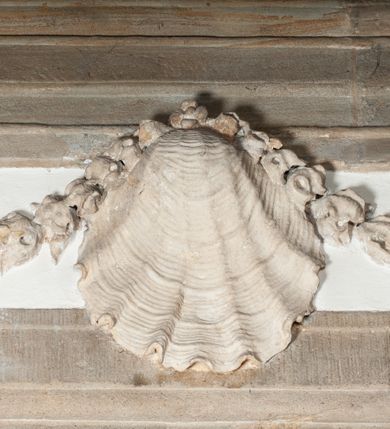 Zdjęcie nr 10: Rzeźba drążona, postać umieszczona na cokole. Święty Jan Ewangelista ukazany w całej postaci, frontalnie, prawą rękę przyciska do piersi w lewej opuszczonej wzdłuż ciała trzyma zamkniętą księgę. Twarz pociągła, o pełnych policzkach z długim nosem, małymi ustami oraz jasnoniebieskimi oczami, okolona krótkimi brązowymi włosami układającymi się w pukle. Święty jest ubrany w zieloną tunikę z wąskimi rękawami opadającą do podstawy płytkimi, miękkimi fałdami oraz złoty płaszcz spięty na dekolcie, zarzucony na ramiona, podtrzymywany z przodu przez prawe przedramię. Obok bosych stóp świętego, po jego prawej stronie ukazany biały orzeł z rozpostartymi skrzydłami.