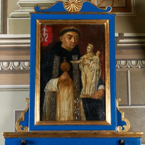 Zdjęcie nr 1: Feretron z obrazem w kształcie stojącego prostokąta z przedstawieniem św. Jacka.  Święty ukazany frontalnie, w półpostaci, z głową wysuniętą delikatnie do przodu i wzrokiem skierowanym przed siebie. Ręce ugięte, w lewej rzeźba Matki Boskiej z Dzieciątkiem, w prawej puszka na komunikanty. Ma okrągłą, małą twarz o ciemnych oczach, wąskim nosie i ustach, na głowie ma wyciętą tonsurę. Jest ubrany w biały habit dominikański oraz czarną pelerynę z kapturem, na to ma założoną srebrzystą stułę. W lewym, górnym rogu obrazu herb rodziny Odrowążów. Obraz oprawiono w profilowaną ramę, ustawiono na prostopadłościennej, wyciętej od dołu podstawie z otworami na drążki, ujęto spływami wolutowymi i zamknięto od góry łukiem wklęsło-wypukłym przedzielonym rozetą zwieńczoną krzyżem. Struktura malowana na kolor niebieski; profile złocone.