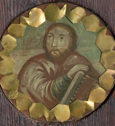 Zdjęcie nr 2: Ołtarzyk architektoniczny, jednokondygnacyjny ze zwieńczeniem, na cokole; w formie aediculi, ujętej parą kolumienek ustawionych na wyodrębnionych cokołach, dźwigających pełne belkowanie wyłamane na ich osi, na którym znajdują się kule i tralki. W polu głównym wnęka w kształcie stojącego prostokąta, ujęta profilowaną ramą z wizerunkiem Matki Boskiej. W partii cokołu pięć medalionów, z których cztery zdobione są rozetami z papieru, środkowa jest pusta. Fryz dekorowany pięcioma medalionami z papierowymi rozetami. Ołtarzyk ujęty skrzydłami o fantazyjnym wykroju, z malowanym wzorem wzdłuż krawędzi. Każde ozdobione czterema medalionami z malowanymi popiersiami apostołów (trzech ewangelistów i św. Macieja) i papierowymi rozetami oraz płaskorzeźbionym ornamentem kandelabrowym. Zwieńczenie o fantazyjnej formie zbliżonej do kwadratu o wklęsłych bokach i ściętych górnych narożach obwiedzionych gzymsem, zakończone małym szczytem z rozetą. W polu medalion z przedstawieniem męczeństwa św. Sebastiana, flankowany płaskorzeźbionym ornamentem kandelabrowym. 
Obraz Matki Boskiej w formie stojącego prostokąta. W centrum półpostać Marii, zwróconej w trzech czwartych w prawo, z pochyloną głową i dłońmi złożonymi w geście modlitwy. Twarz ma owalną, o pełnych policzkach, okrągłych, półprzymkniętych oczach, prostym nosie i małych, pełnych ustach. Ubrana jest w brązową suknię, pod szyją ma podwikę, na ramiona i głowę zarzucony niebieski płaszcz z czerwoną podszewką. Wokół jej głowy złocony nimb. Maria ukazana jest na tle niebiesko-różowego nieba. 











