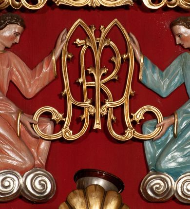 Zdjęcie nr 4: Obraz w kształcie stojącego prostokąta z przedstawieniem Matki Boskiej Nieustającej Pomocy. Maria ukazana w półpostaci, frontalnie, z Dzieciątkiem Jezus na lewym ręku. Dzieciątko widoczne z prawego profilu, z głową odwróconą do tyłu, oburącz ujmuje dłoń Marii. Owalne twarze postaci charakteryzują linearnie opracowane rysy, z długimi, wąskimi nosami oraz drobnymi ustami. Oczy Marii mają migdałowy kształt, jej wzrok skierowany jest na wprost. Matka Boska ubrana jest w czerwoną suknię z długimi rękawami ze złotymi obszyciami oraz ciemnoniebieski płaszcz nałożony na głowę. Dzieciątko ubrane jest w zieloną sukienkę i czerwony płaszcz, z jego lewej stopy zsuwa się sandał. Jezus spogląda w kierunku niewielkiej sylwetki jednego z dwóch archaniołów znajdującego się po prawej stronie – archanioła Gabriela. Po drugiej stronie jest archanioł Michał, obaj trzymają w dłoniach narzędzia męki Pańskiej: Michał (włócznię i gąbkę z octem), Gabriel (krzyż). Na głowach Maryi i Dzieciątka znajdują się blaszane, ażurowe korony z aplikowanymi sztucznymi kamieniami, a wokół głów ryte nimby: Matki Boskiej dekorowany bogatą wicią floralną, u Dzieciątka nimb krzyżowy. Wszystkie postacie są podpisane inicjałami: nad głową Marii, po lewej stronie obrazu widnieją litery „MP”, a po prawej „ΘΥ”; następnie po lewej stronie obrazu, nad głową archanioła Michała znajdują się litery:„ΟΡМ”, a nad głową archanioła Gabriela: „OΡГ” i dalej, po prawej stronie obrazu, obok Dzieciątka Jezus litery: „IC-XC”. Tło jest złocone. Obraz ujęty jest prostokątną, profilowaną ramą zdobioną od zewnątrz ażurową wicią roślinną. 
