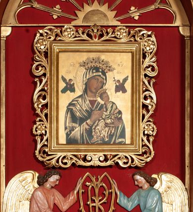 Zdjęcie nr 3: Obraz w kształcie stojącego prostokąta z przedstawieniem Matki Boskiej Nieustającej Pomocy. Maria ukazana w półpostaci, frontalnie, z Dzieciątkiem Jezus na lewym ręku. Dzieciątko widoczne z prawego profilu, z głową odwróconą do tyłu, oburącz ujmuje dłoń Marii. Owalne twarze postaci charakteryzują linearnie opracowane rysy, z długimi, wąskimi nosami oraz drobnymi ustami. Oczy Marii mają migdałowy kształt, jej wzrok skierowany jest na wprost. Matka Boska ubrana jest w czerwoną suknię z długimi rękawami ze złotymi obszyciami oraz ciemnoniebieski płaszcz nałożony na głowę. Dzieciątko ubrane jest w zieloną sukienkę i czerwony płaszcz, z jego lewej stopy zsuwa się sandał. Jezus spogląda w kierunku niewielkiej sylwetki jednego z dwóch archaniołów znajdującego się po prawej stronie – archanioła Gabriela. Po drugiej stronie jest archanioł Michał, obaj trzymają w dłoniach narzędzia męki Pańskiej: Michał (włócznię i gąbkę z octem), Gabriel (krzyż). Na głowach Maryi i Dzieciątka znajdują się blaszane, ażurowe korony z aplikowanymi sztucznymi kamieniami, a wokół głów ryte nimby: Matki Boskiej dekorowany bogatą wicią floralną, u Dzieciątka nimb krzyżowy. Wszystkie postacie są podpisane inicjałami: nad głową Marii, po lewej stronie obrazu widnieją litery „MP”, a po prawej „ΘΥ”; następnie po lewej stronie obrazu, nad głową archanioła Michała znajdują się litery:„ΟΡМ”, a nad głową archanioła Gabriela: „OΡГ” i dalej, po prawej stronie obrazu, obok Dzieciątka Jezus litery: „IC-XC”. Tło jest złocone. Obraz ujęty jest prostokątną, profilowaną ramą zdobioną od zewnątrz ażurową wicią roślinną. 
