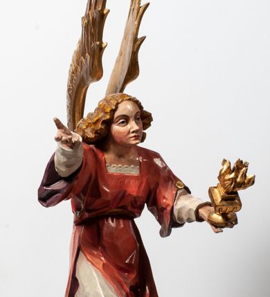 Zdjęcie nr 7: Tabernakulum proste, w formie prostopadłościennej skrzynki, o złotych drzwiczkach z wytłaczaną formą równoramiennego krzyża i wypukłą srebrną rybą oraz koszem z chlebem pośrodku. Po obu stronach, na niewysokich postumentach umieszczone dwa klęczące anioły z wysokimi, uniesionymi do góry skrzydłami, zwróconymi ku środkowi. Twarze o delikatnych rysach, silnie zarumienionych policzkach z 
długimi nosami, głęboko osadzonymi oczami i wysuniętym podbródkiem. Włosy długie, bujne, skręcone w duże pukle po bokach głowy. Anioły ubrane są w białe suknie i czerwone dalmatyki o fioletowych podszewkach. Anioł po lewej stronie trzyma w dłoniach kadzielnicę, a anioł po prawej płomienisty wazon. Polichromie w odsłoniętych partiach ciała naturalistyczne. 


