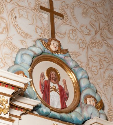 Zdjęcie nr 10: Nastawa ołtarzowa architektoniczna, jednokondygnacyjna ze zwieńczeniem. Ołtarz drewniany, flankowany dwoma filarami na niskich cokołach, pośrodku ażurowa, neogotycka krata; mensa drewniana. Tabernakulum w formie prostopadłościennej skrzynki, ustawione na niskim cokole, ujęte parą pilastrów w formie spływów wolutowych ozdobionych liśćmi akantu i kampanulami na trzonach. Na ściance przedniej drzwiczki w kształcie stojącego prostokąta. W polu w płycinie o analogicznym kształcie łaciński krzyżyk o trójlistnie zakończonych ramionach. Całość zamknięta profilowanym gzymsem. Po bokach tabernakulum stoją dwie figury klęczących aniołów. Nastawa ustawiona na wyłamanej pośrodku predelli, podtrzymującej podpory: parę kolumn o delikatnie zwężających się ku górze, kanelowanych trzonach z kompozytowymi pilastrami oraz wewnętrzną parę wklęsłych pilastrów o gładkich trzonach i stylizowanych kapitelach, wspierającymi przerwane nad osią główną belkowanie. W polu środkowym wnęka w kształcie stojącego prostokąta zamknięta od góry trzema wolutami, a od dołu fantazyjnie wycięta. Wewnątrz obraz Matki Boskiej Częstochowskiej. Poniżej, złotymi literami napis: „PAMIĄTKA NAWIEDZENIA / w Woli Batorskiej / 22/23.VIII.1968 r(oku)&quot;. Po lewej stronie ustawiona rzeźba św. Piotra, a po prawej św. Pawła. Zwieńczenie w formie owalu z płaskorzeźbionym przedstawieniem Najświętszego Serca Pana Jezusa, otoczone obłokami z trzema uskrzydlonymi główkami aniołków. Na szczycie zatknięty prosty, łaciński krzyżyk. Struktura polichromowana na kolor jasnobeżowy, detale i ornamentyka złocone i srebrzone.