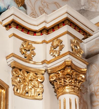 Zdjęcie nr 12: Nastawa ołtarzowa architektoniczna, jednokondygnacyjna ze zwieńczeniem. Ołtarz drewniany, flankowany dwoma filarami na niskich cokołach, pośrodku ażurowa, neogotycka krata; mensa drewniana. Tabernakulum w formie prostopadłościennej skrzynki, ustawione na niskim cokole, ujęte parą pilastrów w formie spływów wolutowych ozdobionych liśćmi akantu i kampanulami na trzonach. Na ściance przedniej drzwiczki w kształcie stojącego prostokąta. W polu w płycinie o analogicznym kształcie łaciński krzyżyk o trójlistnie zakończonych ramionach. Całość zamknięta profilowanym gzymsem. Po bokach tabernakulum stoją dwie figury klęczących aniołów. Nastawa ustawiona na wyłamanej pośrodku predelli, podtrzymującej podpory: parę kolumn o delikatnie zwężających się ku górze, kanelowanych trzonach z kompozytowymi pilastrami oraz wewnętrzną parę wklęsłych pilastrów o gładkich trzonach i stylizowanych kapitelach, wspierającymi przerwane nad osią główną belkowanie. W polu środkowym wnęka w kształcie stojącego prostokąta zamknięta od góry trzema wolutami, a od dołu fantazyjnie wycięta. Wewnątrz obraz Matki Boskiej Częstochowskiej. Poniżej, złotymi literami napis: „PAMIĄTKA NAWIEDZENIA / w Woli Batorskiej / 22/23.VIII.1968 r(oku)". Po lewej stronie ustawiona rzeźba św. Piotra, a po prawej św. Pawła. Zwieńczenie w formie owalu z płaskorzeźbionym przedstawieniem Najświętszego Serca Pana Jezusa, otoczone obłokami z trzema uskrzydlonymi główkami aniołków. Na szczycie zatknięty prosty, łaciński krzyżyk. Struktura polichromowana na kolor jasnobeżowy, detale i ornamentyka złocone i srebrzone.