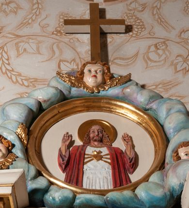 Zdjęcie nr 11: Nastawa ołtarzowa architektoniczna, jednokondygnacyjna ze zwieńczeniem. Ołtarz drewniany, flankowany dwoma filarami na niskich cokołach, pośrodku ażurowa, neogotycka krata; mensa drewniana. Tabernakulum w formie prostopadłościennej skrzynki, ustawione na niskim cokole, ujęte parą pilastrów w formie spływów wolutowych ozdobionych liśćmi akantu i kampanulami na trzonach. Na ściance przedniej drzwiczki w kształcie stojącego prostokąta. W polu w płycinie o analogicznym kształcie łaciński krzyżyk o trójlistnie zakończonych ramionach. Całość zamknięta profilowanym gzymsem. Po bokach tabernakulum stoją dwie figury klęczących aniołów. Nastawa ustawiona na wyłamanej pośrodku predelli, podtrzymującej podpory: parę kolumn o delikatnie zwężających się ku górze, kanelowanych trzonach z kompozytowymi pilastrami oraz wewnętrzną parę wklęsłych pilastrów o gładkich trzonach i stylizowanych kapitelach, wspierającymi przerwane nad osią główną belkowanie. W polu środkowym wnęka w kształcie stojącego prostokąta zamknięta od góry trzema wolutami, a od dołu fantazyjnie wycięta. Wewnątrz obraz Matki Boskiej Częstochowskiej. Poniżej, złotymi literami napis: „PAMIĄTKA NAWIEDZENIA / w Woli Batorskiej / 22/23.VIII.1968 r(oku)&quot;. Po lewej stronie ustawiona rzeźba św. Piotra, a po prawej św. Pawła. Zwieńczenie w formie owalu z płaskorzeźbionym przedstawieniem Najświętszego Serca Pana Jezusa, otoczone obłokami z trzema uskrzydlonymi główkami aniołków. Na szczycie zatknięty prosty, łaciński krzyżyk. Struktura polichromowana na kolor jasnobeżowy, detale i ornamentyka złocone i srebrzone.