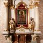 Zdjęcie nr 1: Nastawa ołtarzowa architektoniczna, jednokondygnacyjna ze zwieńczeniem. Ołtarz drewniany, flankowany dwoma filarami na niskich cokołach, pośrodku ażurowa, neogotycka krata; mensa drewniana. Tabernakulum w formie prostopadłościennej skrzynki, ustawione na niskim cokole, ujęte parą pilastrów w formie spływów wolutowych ozdobionych liśćmi akantu i kampanulami na trzonach. Na ściance przedniej drzwiczki w kształcie stojącego prostokąta. W polu w płycinie o analogicznym kształcie łaciński krzyżyk o trójlistnie zakończonych ramionach. Całość zamknięta profilowanym gzymsem. Po bokach tabernakulum stoją dwie figury klęczących aniołów. Nastawa ustawiona na wyłamanej pośrodku predelli, podtrzymującej podpory: parę kolumn o delikatnie zwężających się ku górze, kanelowanych trzonach z kompozytowymi pilastrami oraz wewnętrzną parę wklęsłych pilastrów o gładkich trzonach i stylizowanych kapitelach, wspierającymi przerwane nad osią główną belkowanie. W polu środkowym wnęka w kształcie stojącego prostokąta zamknięta od góry trzema wolutami, a od dołu fantazyjnie wycięta. Wewnątrz obraz Matki Boskiej Częstochowskiej. Poniżej, złotymi literami napis: „PAMIĄTKA NAWIEDZENIA / w Woli Batorskiej / 22/23.VIII.1968 r(oku)". Po lewej stronie ustawiona rzeźba św. Piotra, a po prawej św. Pawła. Zwieńczenie w formie owalu z płaskorzeźbionym przedstawieniem Najświętszego Serca Pana Jezusa, otoczone obłokami z trzema uskrzydlonymi główkami aniołków. Na szczycie zatknięty prosty, łaciński krzyżyk. Struktura polichromowana na kolor jasnobeżowy, detale i ornamentyka złocone i srebrzone.