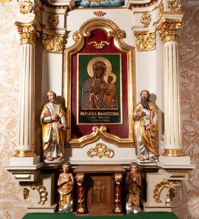 Zdjęcie nr 6: Nastawa ołtarzowa architektoniczna, jednokondygnacyjna ze zwieńczeniem. Ołtarz drewniany, flankowany dwoma filarami na niskich cokołach, pośrodku ażurowa, neogotycka krata; mensa drewniana. Tabernakulum w formie prostopadłościennej skrzynki, ustawione na niskim cokole, ujęte parą pilastrów w formie spływów wolutowych ozdobionych liśćmi akantu i kampanulami na trzonach. Na ściance przedniej drzwiczki w kształcie stojącego prostokąta. W polu w płycinie o analogicznym kształcie łaciński krzyżyk o trójlistnie zakończonych ramionach. Całość zamknięta profilowanym gzymsem. Po bokach tabernakulum stoją dwie figury klęczących aniołów. Nastawa ustawiona na wyłamanej pośrodku predelli, podtrzymującej podpory: parę kolumn o delikatnie zwężających się ku górze, kanelowanych trzonach z kompozytowymi pilastrami oraz wewnętrzną parę wklęsłych pilastrów o gładkich trzonach i stylizowanych kapitelach, wspierającymi przerwane nad osią główną belkowanie. W polu środkowym wnęka w kształcie stojącego prostokąta zamknięta od góry trzema wolutami, a od dołu fantazyjnie wycięta. Wewnątrz obraz Matki Boskiej Częstochowskiej. Poniżej, złotymi literami napis: „PAMIĄTKA NAWIEDZENIA / w Woli Batorskiej / 22/23.VIII.1968 r(oku)". Po lewej stronie ustawiona rzeźba św. Piotra, a po prawej św. Pawła. Zwieńczenie w formie owalu z płaskorzeźbionym przedstawieniem Najświętszego Serca Pana Jezusa, otoczone obłokami z trzema uskrzydlonymi główkami aniołków. Na szczycie zatknięty prosty, łaciński krzyżyk. Struktura polichromowana na kolor jasnobeżowy, detale i ornamentyka złocone i srebrzone.