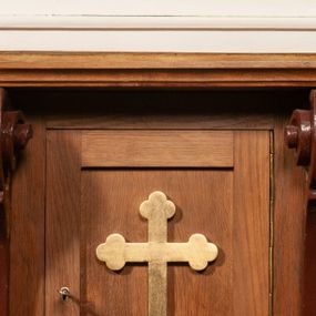 Zdjęcie nr 1: Tabernakulum w formie prostopadłościennej skrzynki, ustawione na niskim cokole, ujęte parą pilastrów w formie spływów wolutowych ozdobionych liśćmi akantu i kampanulami na trzonach. Na ściance przedniej drzwiczki w kształcie stojącego prostokąta. W polu w płycinie o analogicznym kształcie łaciński krzyżyk o trójlistnie zakończonych ramionach. Całość zamknięta profilowanym gzymsem. 