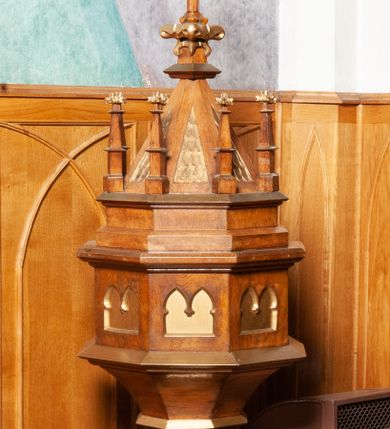 Zdjęcie nr 1: Chrzcielnica ustawiona na niskim, prostopadłościennym cokole na planie kwadratu, stopa profilowana, ścięta na narożach. Trzon okrągły, zakończony głowicą z motywem roślinnym. Czara od spodu ośmioboczna, ujęta w dwa profilowane, ośmioboczne pierścienie, malowane na kolor złoty. Brzusiec z płycinami wypełnionymi dwułęcznymi, maswerkowymi arkadami z noskami. Zwieńczenie stożkowate, ośmioboczne, zdobione w polach ornamentem łuskowym malowanym na złoto. W narożach pinakle z kwiatonami. Szczyt zwieńczony krzyżem na czworobocznym postumencie z kwiatonem. Krzyż z ramionami zakończonymi liliami herbowymi, z promieniami między ramionami. Chrzcielnica lakierowana, detale i ornamentyka malowane na złoto.