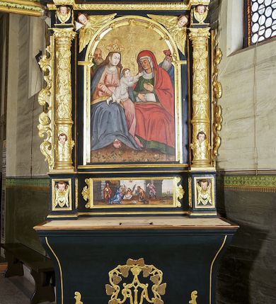 Zdjęcie nr 2: Ołtarz architektoniczny, jednoosiowy, jednokondygnacyjny ze zwieńczeniem, ujęty uszami z ornamentu małżowinowo-chrząstkowego oraz akantu. Mensa drewniana o linii wklęsło-wypukłej, z kamiennym portatylem. Antepedium drewniane, w części centralnej dekorowane płaskorzeźbionym medalionem z wici roślinnej mieszczącym monogram maryjny ujęty po bokach ornamentem roślinnym. Nastawa ustawiona na profilowanym cokole dekorowanym uskrzydlonymi główkami anielskimi. W części środkowej predella ze złoconą płyciną w kształcie leżącego prostokąta ujętego palmetami, wewnątrz której znajduje się obraz ze sceną Pokłonu pasterzy. Retabulum ujęte parą korynckich kolumn ustawionych na wysokich cokołach. Kolumny dźwigają odcinki wyłamanego belkowania zwieńczonego profilowanym gzymsem, na którym ustawiono figury św. Wojciecha i św. Stanisława. Trzony kolumn złocone, w jednej trzeciej wysokości opięte profilowanym okuciem, poniżej którego płaskorzeźbione, uskrzydlone główki anielskie na tle ornamentu okuciowego, a powyżej winna latorośl na tle ornamentu okuciowego. Pole środkowe ołtarza w formie arkady zamkniętej łukiem półkolistym mieści obraz przedstawiający temat Rodziny Marii. W przyłuczach płaskorzeźbione, uskrzydlone główki anielskie. Zwieńczenie ujęte hermowymi pilastrami dźwigającymi niepełne, wyłamane belkowanie z uskrzydloną główką anielską na osi, na którym znajduje się trójkątny, przerwany przyczółek. Na ramionach przyczółka półleżące postaci aniołów, pomiędzy nimi, w osi ołtarza figura Chrystusa Zmartwychwstałego. W polu obraz w kształcie stojącego prostokąta zamkniętego łukiem półokrągłym przedstawiający św. Marcina. Zwieńczenie ujęte uszami utworzonymi z akantu oraz podwieszonej draperii. Struktura ołtarza jest polichromowana na ciemnozielono, ze złoconymi detalami architektonicznymi i ornamentyką. Figury w partiach ciała z naturalistyczną polichromią oraz złoconymi szatami i atrybutami.