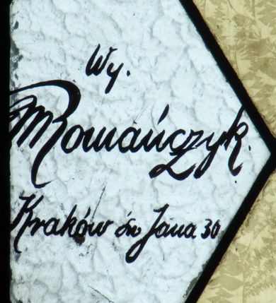 Zdjęcie nr 4: Witraż w kształcie wydłużonego, stojącego prostokąta zamkniętego półkoliście. W centrum kompozycji umieszczony medalion mieszczący popiersie św. Teresy z Lisieux trzymającej krucyfiks i róże. Święta ukazana frontalnie z głową zwróconą w trzech czwartych w lewo. Twarz owalna, o regularnych rysach, z dużymi oczami, wąskim nosem oraz niewielkimi ustami. Święta w rękach złożonych na wysokości piersi trzyma bukiet czerwonych i różowych róż oraz krucyfiks, na który spływają promienie. Teresa ubrana jest w brązowy karmelitański habit z białym płaszczem oraz białą toką i czarnym welonem na głowie. Tło medalionu utrzymane jest odcieniach niebieskiego. Wokół głowy jasnożółty nimb. W górnej części witrażu przedstawione winne grona na tle geometrycznej kompozycji w kolorach żółtym i czerwonym. W dolnej strefie witrażu inskrypcja „FUNDACJA / MŁODZIEŻY ŻEŃSKIEJ R(OKU) P(AŃSKIEGO) 1937” oraz poniżej, w lewym, dolnym rogu sygnatura: „Wy[konał] / M[aksymilian]Romańczyk / Kraków św. Jana 30”. Tło kompozycji wypełnione motywem rombów w kolorach jasnożółtym i białym.