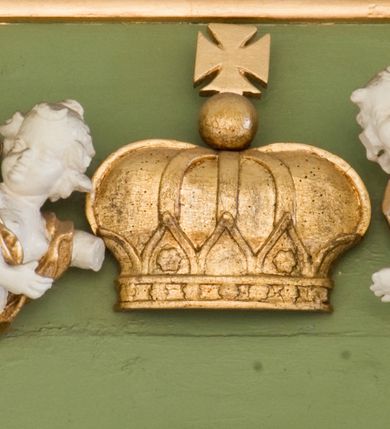 Zdjęcie nr 21: Ołtarz przyścienny, architektoniczny, trójosiowy, dwukondygnacyjny ze zwieńczeniem. Nastawa umieszczona na wysokim, dwudzielnym cokole w górnej części zdobionym na przemian dekoracją płycinową i motywem muszli palmetowej z podwieszoną girlandą kwiatową oraz rozetkami. Cokół wieńczy profilowany gzyms dekorowany kostkowaniem. Antepedium współczesne, marmurowe z umieszczonym centralnie prostym, równoramiennym krzyżem. Na mensie ustawione tabernakulum z tronem wystawienia, o formach architektonicznych, ujęte zdwojonymi, smukłymi kolumienkami o złoconych trzonach umieszczonymi na wysokich cokołach. Podpory dźwigają odcinki pełnego belkowania, na których ustawione złocone figury klęczących aniołów. Część centralna o linii wypukłej, dwukondygnacyjna. W kondygnacji pierwszej złocone drzwiczki z płaskorzeźbionym kielichem z hostią na tle glorii promienistej, powyżej, w kondygnacji drugiej tron wystawienia ujęty rzeźbioną, złoconą kotarą. W zwieńczeniu srebrzona figura baranka apokaliptycznego leżącego na księdze. Nastawa ujęta zdwojonymi, kompozytowymi kolumnami o złoconych trzonach i kapitelach. Pomiędzy kolumnami, w niszach rzeźbione figury św. Piotra (z lewej) i św. Pawła (z prawej), ponad którymi motyw symetrycznie podwieszonej kotary. Kolumny dźwigają odcinki pełnego belkowania z fryzem dekorowanym rozetkami i uskrzydlonymi główkami anielskimi oraz wydatnym gzymsem dekorowanym kostkowaniem. Na osi wewnętrznej pary komun dodatkowo ustawione odcinki półkolistego tympanonu, na których siedzą putta. W polu głównym ołtarza złocona, profilowana rama w kształcie stojącego prostokąta zamkniętego łukiem nadwieszonym mieszcząca barokowy obraz Matki Boskiej z Dzieciątkiem. Nieco powyżej, w osi ołtarza dwa putta unoszące złoconą koronę typu zamkniętego zwieńczoną krzyżem. Kondygnacja druga ujęta parą pilastrów o kompozytowych kapitelach oraz uszami w formie spływów wolutowych, na których siedzące putta. W polu złocona i profilowana rama w kształcie stojącego prostokąta mieszcząca obraz przedstawiający Trójcę Świętą. Całość ołtarza wieńczy profilowany gzyms dekorowany kostkowaniem i zamknięty niskim, trójkątnym przyczółkiem. W polu tympanonu uskrzydlona główka anielska. Struktura ołtarza polichromowana w kolorze jasnozielonym z elementami czerwieni i bieli. Detale architektoniczne, ornamenty oraz szaty postaci złocone.

