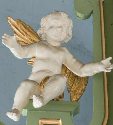 Zdjęcie nr 19: Ołtarz przyścienny, architektoniczny, trójosiowy, dwukondygnacyjny ze zwieńczeniem. Nastawa umieszczona na wysokim, dwudzielnym cokole w górnej części zdobionym na przemian dekoracją płycinową i motywem muszli palmetowej z podwieszoną girlandą kwiatową oraz rozetkami. Cokół wieńczy profilowany gzyms dekorowany kostkowaniem. Antepedium współczesne, marmurowe z umieszczonym centralnie prostym, równoramiennym krzyżem. Na mensie ustawione tabernakulum z tronem wystawienia, o formach architektonicznych, ujęte zdwojonymi, smukłymi kolumienkami o złoconych trzonach umieszczonymi na wysokich cokołach. Podpory dźwigają odcinki pełnego belkowania, na których ustawione złocone figury klęczących aniołów. Część centralna o linii wypukłej, dwukondygnacyjna. W kondygnacji pierwszej złocone drzwiczki z płaskorzeźbionym kielichem z hostią na tle glorii promienistej, powyżej, w kondygnacji drugiej tron wystawienia ujęty rzeźbioną, złoconą kotarą. W zwieńczeniu srebrzona figura baranka apokaliptycznego leżącego na księdze. Nastawa ujęta zdwojonymi, kompozytowymi kolumnami o złoconych trzonach i kapitelach. Pomiędzy kolumnami, w niszach rzeźbione figury św. Piotra (z lewej) i św. Pawła (z prawej), ponad którymi motyw symetrycznie podwieszonej kotary. Kolumny dźwigają odcinki pełnego belkowania z fryzem dekorowanym rozetkami i uskrzydlonymi główkami anielskimi oraz wydatnym gzymsem dekorowanym kostkowaniem. Na osi wewnętrznej pary komun dodatkowo ustawione odcinki półkolistego tympanonu, na których siedzą putta. W polu głównym ołtarza złocona, profilowana rama w kształcie stojącego prostokąta zamkniętego łukiem nadwieszonym mieszcząca barokowy obraz Matki Boskiej z Dzieciątkiem. Nieco powyżej, w osi ołtarza dwa putta unoszące złoconą koronę typu zamkniętego zwieńczoną krzyżem. Kondygnacja druga ujęta parą pilastrów o kompozytowych kapitelach oraz uszami w formie spływów wolutowych, na których siedzące putta. W polu złocona i profilowana rama w kształcie stojącego prostokąta mieszcząca obraz przedstawiający Trójcę Świętą. Całość ołtarza wieńczy profilowany gzyms dekorowany kostkowaniem i zamknięty niskim, trójkątnym przyczółkiem. W polu tympanonu uskrzydlona główka anielska. Struktura ołtarza polichromowana w kolorze jasnozielonym z elementami czerwieni i bieli. Detale architektoniczne, ornamenty oraz szaty postaci złocone.

