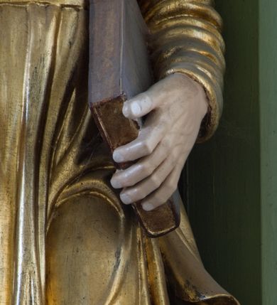 Zdjęcie nr 42: Ołtarz przyścienny, architektoniczny, trójosiowy, dwukondygnacyjny ze zwieńczeniem. Nastawa umieszczona na wysokim, dwudzielnym cokole w górnej części zdobionym na przemian dekoracją płycinową i motywem muszli palmetowej z podwieszoną girlandą kwiatową oraz rozetkami. Cokół wieńczy profilowany gzyms dekorowany kostkowaniem. Antepedium współczesne, marmurowe z umieszczonym centralnie prostym, równoramiennym krzyżem. Na mensie ustawione tabernakulum z tronem wystawienia, o formach architektonicznych, ujęte zdwojonymi, smukłymi kolumienkami o złoconych trzonach umieszczonymi na wysokich cokołach. Podpory dźwigają odcinki pełnego belkowania, na których ustawione złocone figury klęczących aniołów. Część centralna o linii wypukłej, dwukondygnacyjna. W kondygnacji pierwszej złocone drzwiczki z płaskorzeźbionym kielichem z hostią na tle glorii promienistej, powyżej, w kondygnacji drugiej tron wystawienia ujęty rzeźbioną, złoconą kotarą. W zwieńczeniu srebrzona figura baranka apokaliptycznego leżącego na księdze. Nastawa ujęta zdwojonymi, kompozytowymi kolumnami o złoconych trzonach i kapitelach. Pomiędzy kolumnami, w niszach rzeźbione figury św. Piotra (z lewej) i św. Pawła (z prawej), ponad którymi motyw symetrycznie podwieszonej kotary. Kolumny dźwigają odcinki pełnego belkowania z fryzem dekorowanym rozetkami i uskrzydlonymi główkami anielskimi oraz wydatnym gzymsem dekorowanym kostkowaniem. Na osi wewnętrznej pary komun dodatkowo ustawione odcinki półkolistego tympanonu, na których siedzą putta. W polu głównym ołtarza złocona, profilowana rama w kształcie stojącego prostokąta zamkniętego łukiem nadwieszonym mieszcząca barokowy obraz Matki Boskiej z Dzieciątkiem. Nieco powyżej, w osi ołtarza dwa putta unoszące złoconą koronę typu zamkniętego zwieńczoną krzyżem. Kondygnacja druga ujęta parą pilastrów o kompozytowych kapitelach oraz uszami w formie spływów wolutowych, na których siedzące putta. W polu złocona i profilowana rama w kształcie stojącego prostokąta mieszcząca obraz przedstawiający Trójcę Świętą. Całość ołtarza wieńczy profilowany gzyms dekorowany kostkowaniem i zamknięty niskim, trójkątnym przyczółkiem. W polu tympanonu uskrzydlona główka anielska. Struktura ołtarza polichromowana w kolorze jasnozielonym z elementami czerwieni i bieli. Detale architektoniczne, ornamenty oraz szaty postaci złocone.

