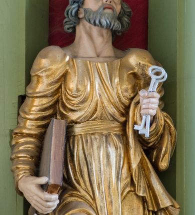 Zdjęcie nr 33: Ołtarz przyścienny, architektoniczny, trójosiowy, dwukondygnacyjny ze zwieńczeniem. Nastawa umieszczona na wysokim, dwudzielnym cokole w górnej części zdobionym na przemian dekoracją płycinową i motywem muszli palmetowej z podwieszoną girlandą kwiatową oraz rozetkami. Cokół wieńczy profilowany gzyms dekorowany kostkowaniem. Antepedium współczesne, marmurowe z umieszczonym centralnie prostym, równoramiennym krzyżem. Na mensie ustawione tabernakulum z tronem wystawienia, o formach architektonicznych, ujęte zdwojonymi, smukłymi kolumienkami o złoconych trzonach umieszczonymi na wysokich cokołach. Podpory dźwigają odcinki pełnego belkowania, na których ustawione złocone figury klęczących aniołów. Część centralna o linii wypukłej, dwukondygnacyjna. W kondygnacji pierwszej złocone drzwiczki z płaskorzeźbionym kielichem z hostią na tle glorii promienistej, powyżej, w kondygnacji drugiej tron wystawienia ujęty rzeźbioną, złoconą kotarą. W zwieńczeniu srebrzona figura baranka apokaliptycznego leżącego na księdze. Nastawa ujęta zdwojonymi, kompozytowymi kolumnami o złoconych trzonach i kapitelach. Pomiędzy kolumnami, w niszach rzeźbione figury św. Piotra (z lewej) i św. Pawła (z prawej), ponad którymi motyw symetrycznie podwieszonej kotary. Kolumny dźwigają odcinki pełnego belkowania z fryzem dekorowanym rozetkami i uskrzydlonymi główkami anielskimi oraz wydatnym gzymsem dekorowanym kostkowaniem. Na osi wewnętrznej pary komun dodatkowo ustawione odcinki półkolistego tympanonu, na których siedzą putta. W polu głównym ołtarza złocona, profilowana rama w kształcie stojącego prostokąta zamkniętego łukiem nadwieszonym mieszcząca barokowy obraz Matki Boskiej z Dzieciątkiem. Nieco powyżej, w osi ołtarza dwa putta unoszące złoconą koronę typu zamkniętego zwieńczoną krzyżem. Kondygnacja druga ujęta parą pilastrów o kompozytowych kapitelach oraz uszami w formie spływów wolutowych, na których siedzące putta. W polu złocona i profilowana rama w kształcie stojącego prostokąta mieszcząca obraz przedstawiający Trójcę Świętą. Całość ołtarza wieńczy profilowany gzyms dekorowany kostkowaniem i zamknięty niskim, trójkątnym przyczółkiem. W polu tympanonu uskrzydlona główka anielska. Struktura ołtarza polichromowana w kolorze jasnozielonym z elementami czerwieni i bieli. Detale architektoniczne, ornamenty oraz szaty postaci złocone.

