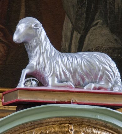 Zdjęcie nr 43: Ołtarz przyścienny, architektoniczny, trójosiowy, dwukondygnacyjny ze zwieńczeniem. Nastawa umieszczona na wysokim, dwudzielnym cokole w górnej części zdobionym na przemian dekoracją płycinową i motywem muszli palmetowej z podwieszoną girlandą kwiatową oraz rozetkami. Cokół wieńczy profilowany gzyms dekorowany kostkowaniem. Antepedium współczesne, marmurowe z umieszczonym centralnie prostym, równoramiennym krzyżem. Na mensie ustawione tabernakulum z tronem wystawienia, o formach architektonicznych, ujęte zdwojonymi, smukłymi kolumienkami o złoconych trzonach umieszczonymi na wysokich cokołach. Podpory dźwigają odcinki pełnego belkowania, na których ustawione złocone figury klęczących aniołów. Część centralna o linii wypukłej, dwukondygnacyjna. W kondygnacji pierwszej złocone drzwiczki z płaskorzeźbionym kielichem z hostią na tle glorii promienistej, powyżej, w kondygnacji drugiej tron wystawienia ujęty rzeźbioną, złoconą kotarą. W zwieńczeniu srebrzona figura baranka apokaliptycznego leżącego na księdze. Nastawa ujęta zdwojonymi, kompozytowymi kolumnami o złoconych trzonach i kapitelach. Pomiędzy kolumnami, w niszach rzeźbione figury św. Piotra (z lewej) i św. Pawła (z prawej), ponad którymi motyw symetrycznie podwieszonej kotary. Kolumny dźwigają odcinki pełnego belkowania z fryzem dekorowanym rozetkami i uskrzydlonymi główkami anielskimi oraz wydatnym gzymsem dekorowanym kostkowaniem. Na osi wewnętrznej pary komun dodatkowo ustawione odcinki półkolistego tympanonu, na których siedzą putta. W polu głównym ołtarza złocona, profilowana rama w kształcie stojącego prostokąta zamkniętego łukiem nadwieszonym mieszcząca barokowy obraz Matki Boskiej z Dzieciątkiem. Nieco powyżej, w osi ołtarza dwa putta unoszące złoconą koronę typu zamkniętego zwieńczoną krzyżem. Kondygnacja druga ujęta parą pilastrów o kompozytowych kapitelach oraz uszami w formie spływów wolutowych, na których siedzące putta. W polu złocona i profilowana rama w kształcie stojącego prostokąta mieszcząca obraz przedstawiający Trójcę Świętą. Całość ołtarza wieńczy profilowany gzyms dekorowany kostkowaniem i zamknięty niskim, trójkątnym przyczółkiem. W polu tympanonu uskrzydlona główka anielska. Struktura ołtarza polichromowana w kolorze jasnozielonym z elementami czerwieni i bieli. Detale architektoniczne, ornamenty oraz szaty postaci złocone.

